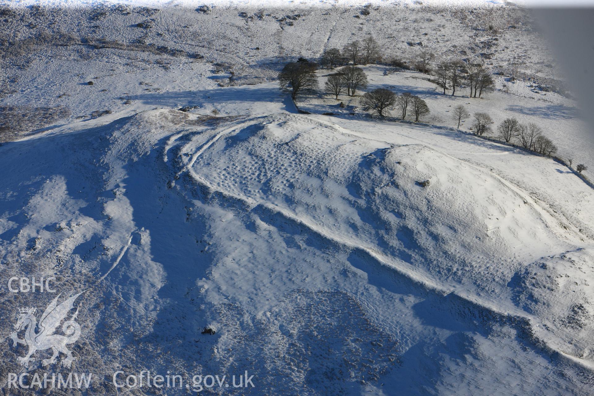 Castle Bank hillfort under snow, north east of Builth Wells. Oblique aerial photograph taken during the Royal Commission?s programme of archaeological aerial reconnaissance by Toby Driver on 15th January 2013.