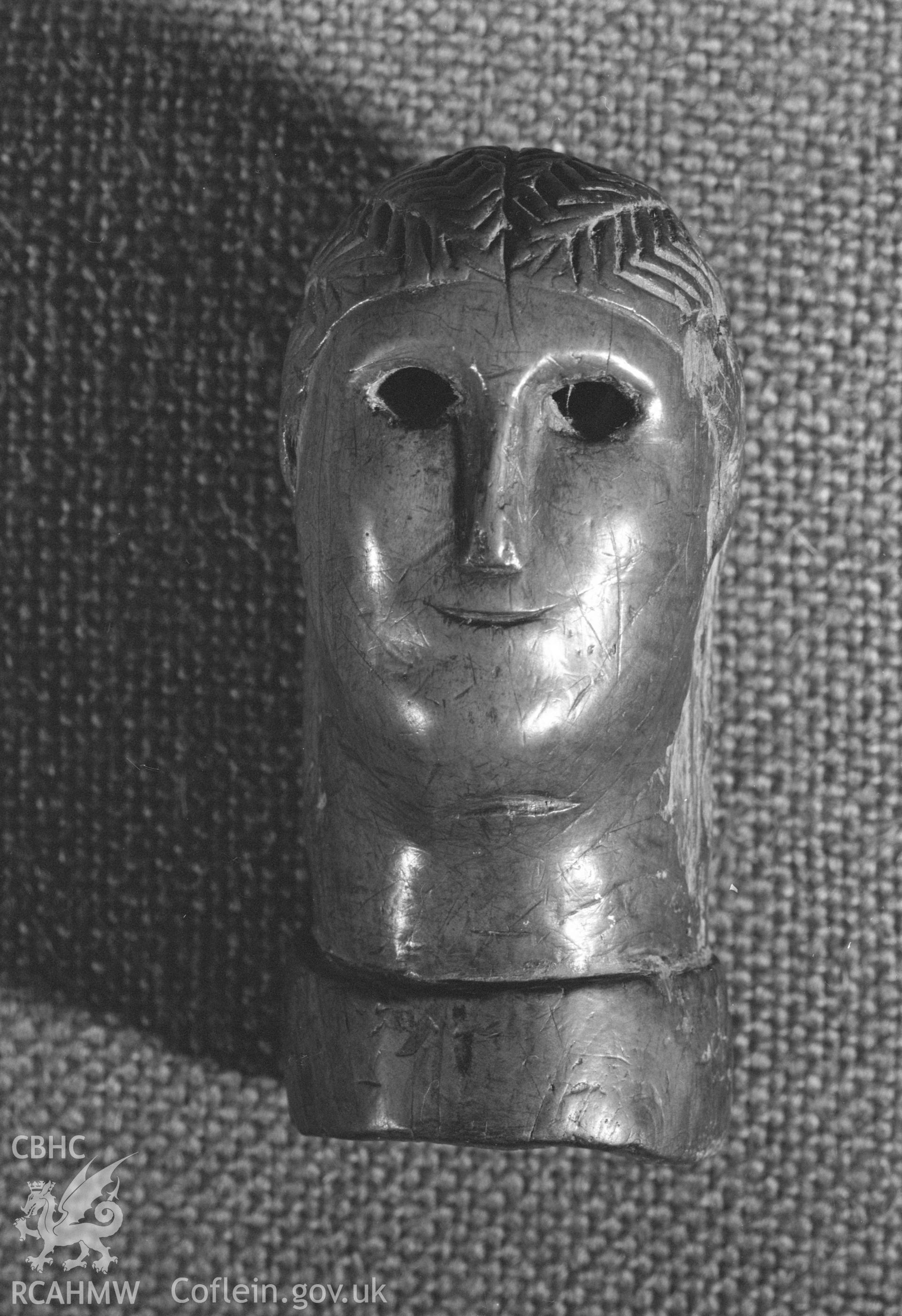 Digital copy of a black and white negative showing carved wooden head from Llanio Roman Fort.