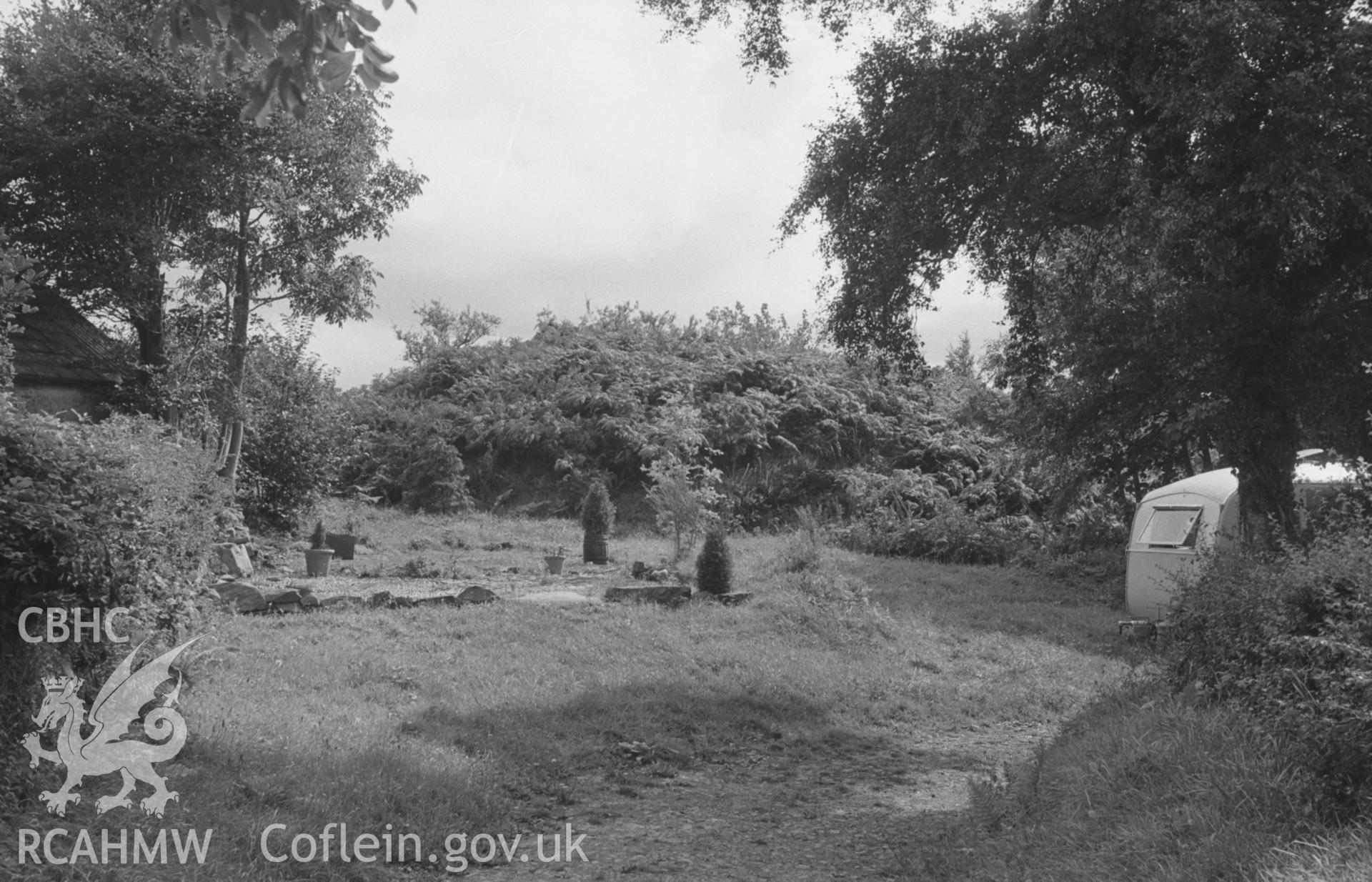 Digital copy of a black and white negative showing Castell Caerwedros motte, with caravan, Caerwedros, south of New Quay. Photographed by Arthur O. Chater in August 1965 from Grid Reference SN 3759 5578, looking east south east.