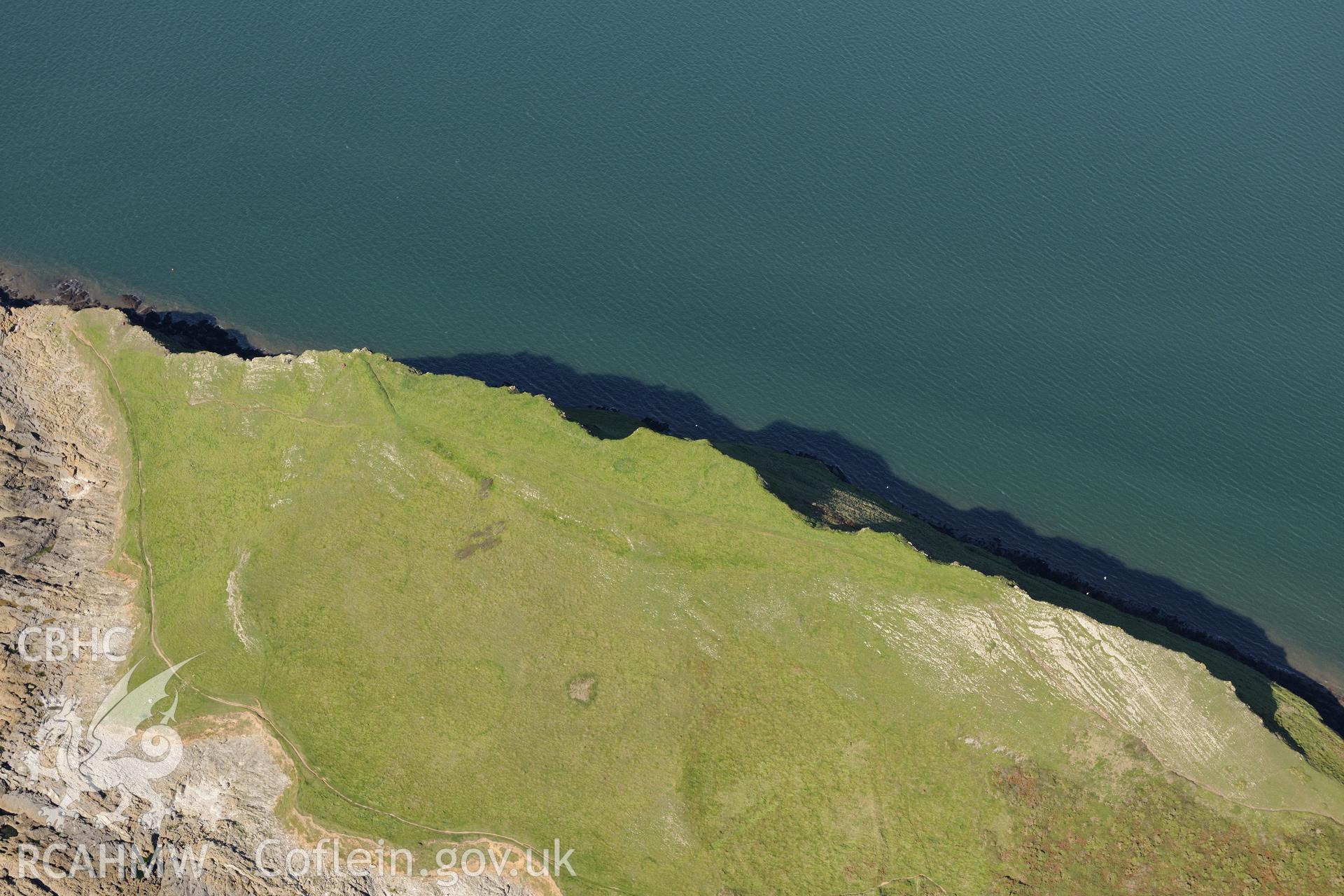 Worm's Head and the enclosure on its north eastern side, near Rhossili, on the western coast of the Gower Peninsula. Oblique aerial photograph taken during the Royal Commission's programme of archaeological aerial reconnaissance by Toby Driver on 30th September 2015.