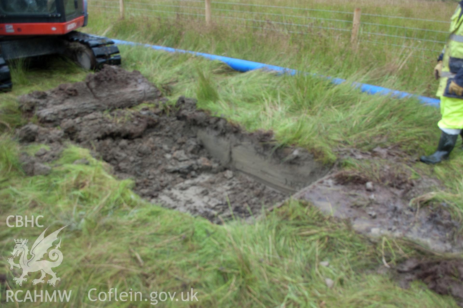 Digital photograph of view from north west of launch pit 1 with topsoil removed in early stages of excavation. Photographed during Gwynedd Archaeological Trust's archaeological watching brief of water main renewal, Dolgellau, 28/07/2017. Project no. G2528.