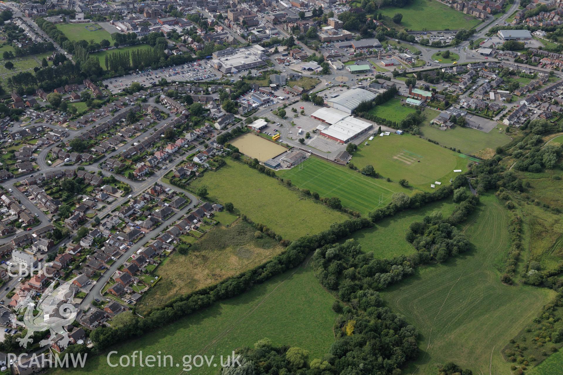 Bryn-yr-Eillon Tumulus (findspot of Mold gold cape) and the surrounding town of Mold. Oblique aerial photograph taken during the Royal Commission's programme of archaeological aerial reconnaissance by Toby Driver on 11th September 2015.