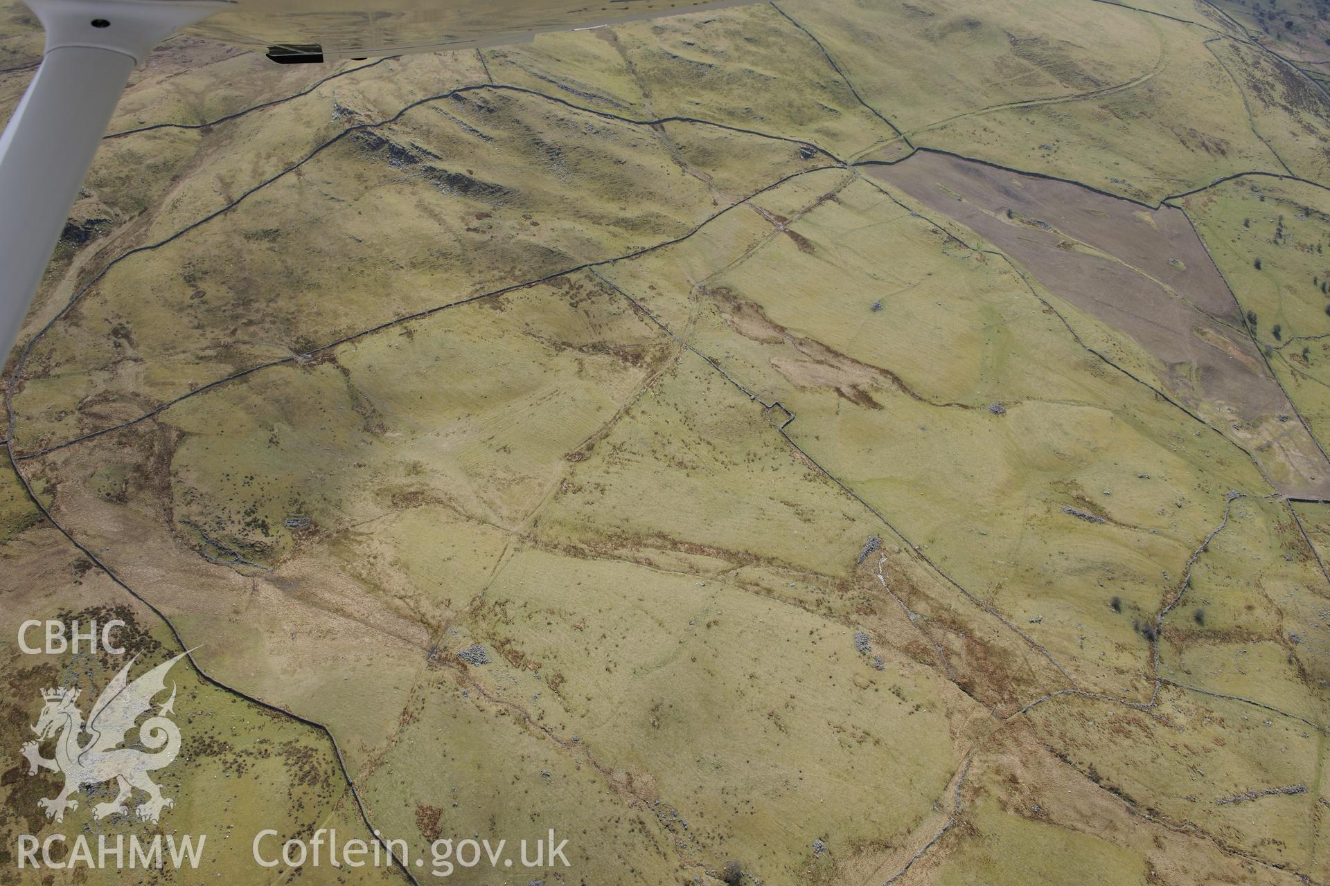 Ffridd Fedw round hut, enclosure, ancient field & kerb cairn; Tyddyn Sion Wyn ring cairn and hut circle north-east of Moel Goedog. Oblique aerial photograph taken during RCAHMW?s programme of archaeological aerial reconnaissance by Toby Driver, 1/05/2013.