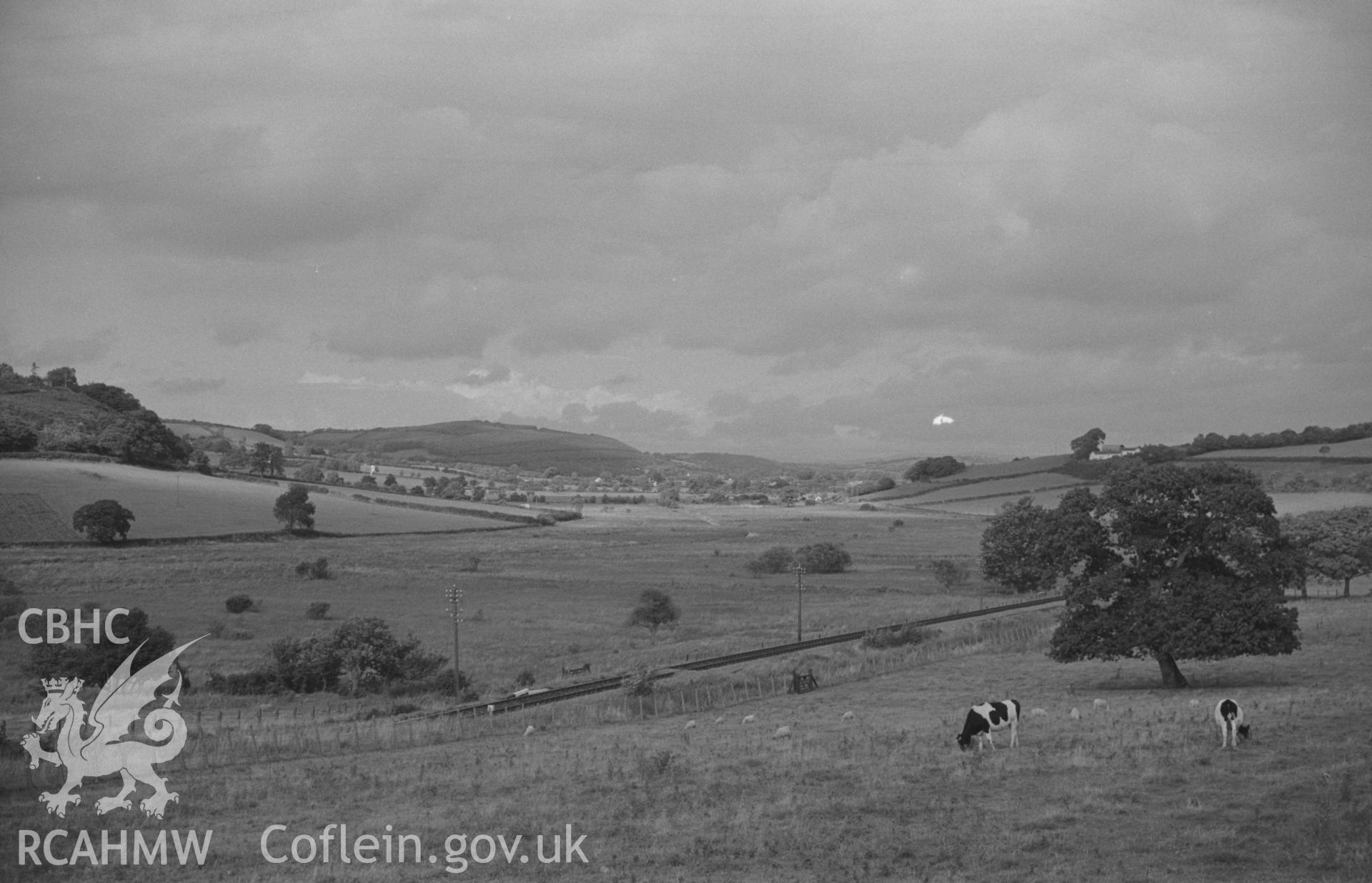 Digital copy of black & white negative showing view of Coed-Parc Farm, Derry Ormond Tower, Bettws Bledrws & Llangybi. Lampeter-Aberystwyth railway in foreground. Photograph by Arthur O. Chater, 4 September 1966, looking north east from Grid Ref SN 590 506.