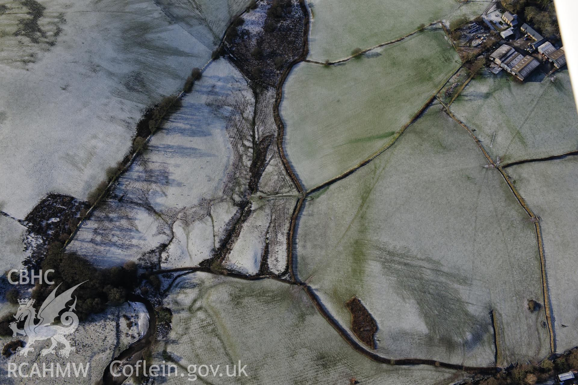 Riverside earthworks to the south-east of Caerau Roman Fort, Beulah, west of Builth Wells. Oblique aerial photograph taken during the Royal Commission?s programme of archaeological aerial reconnaissance by Toby Driver on 15th January 2013.