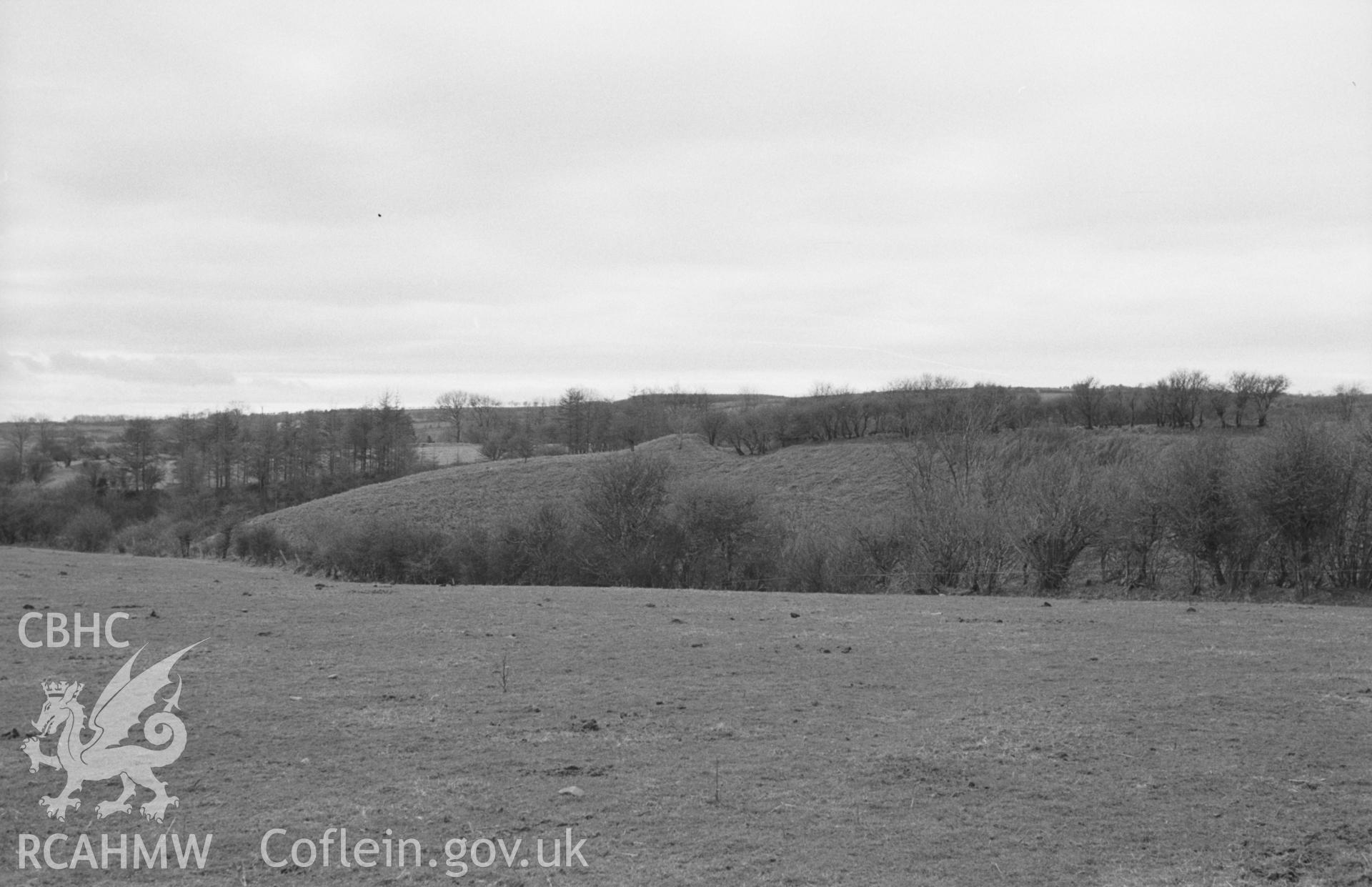 Digital copy of a black and white negative showing ramparrt (centre) of Castell Moeddyn-Fach, north west of Lampeter. Photographed by Arthur O. Chater in April 1965 from across the Grannell valley, Grid Reference SN 4771 5143, looking west.