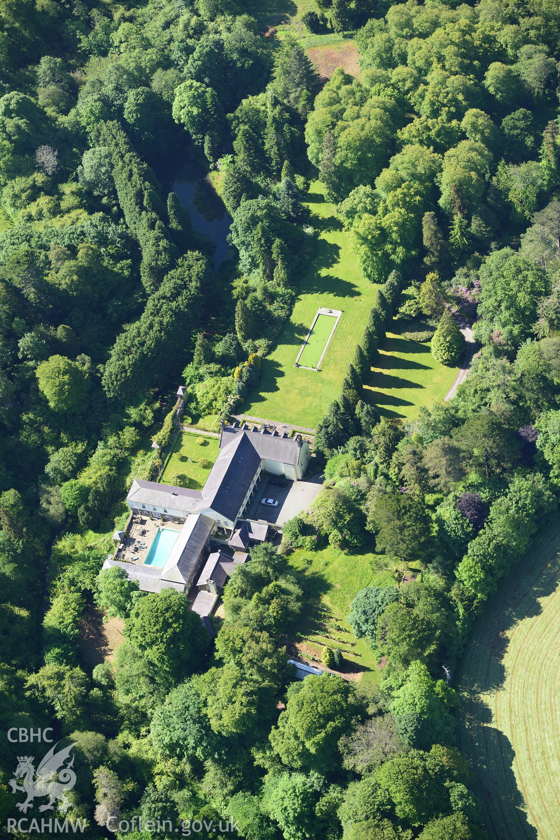 Plas Boduan surrounded by its park and gardens. Oblique aerial photograph taken during the Royal Commission's programme of archaeological aerial reconnaissance by Toby Driver on 23rd June 2015.