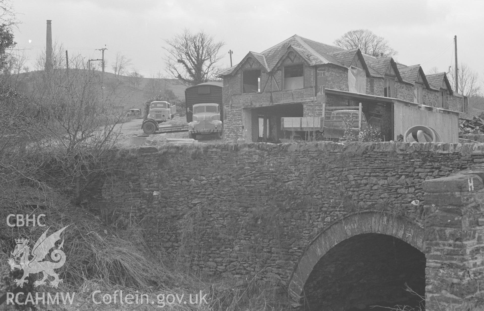 Digital copy of a black and white negative showing view of Derry-Ormond Tower, old sawmill and bridge over Nant Dyfel, 200m west of the church. Photographed by Arthur O. Chater on 7th April 1968 looking west south west from Grid Reference SN 594 520.