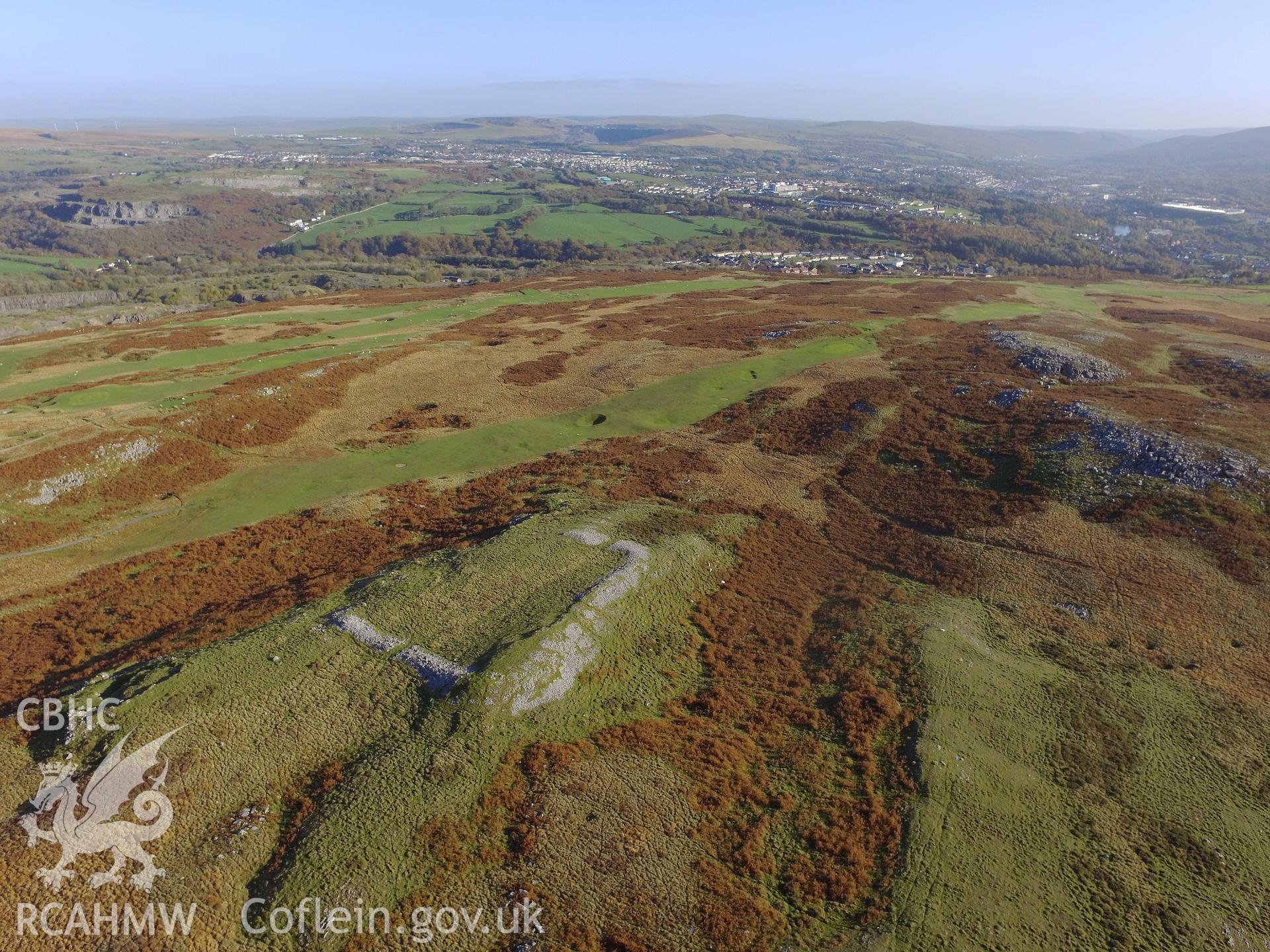 Aerial view from the north west of Cefn Cilsanws enclosure, Vaynor, with the town of Merthyr Tydfil beyond. Colour photograph taken by Paul R. Davis on 22nd October 2018.