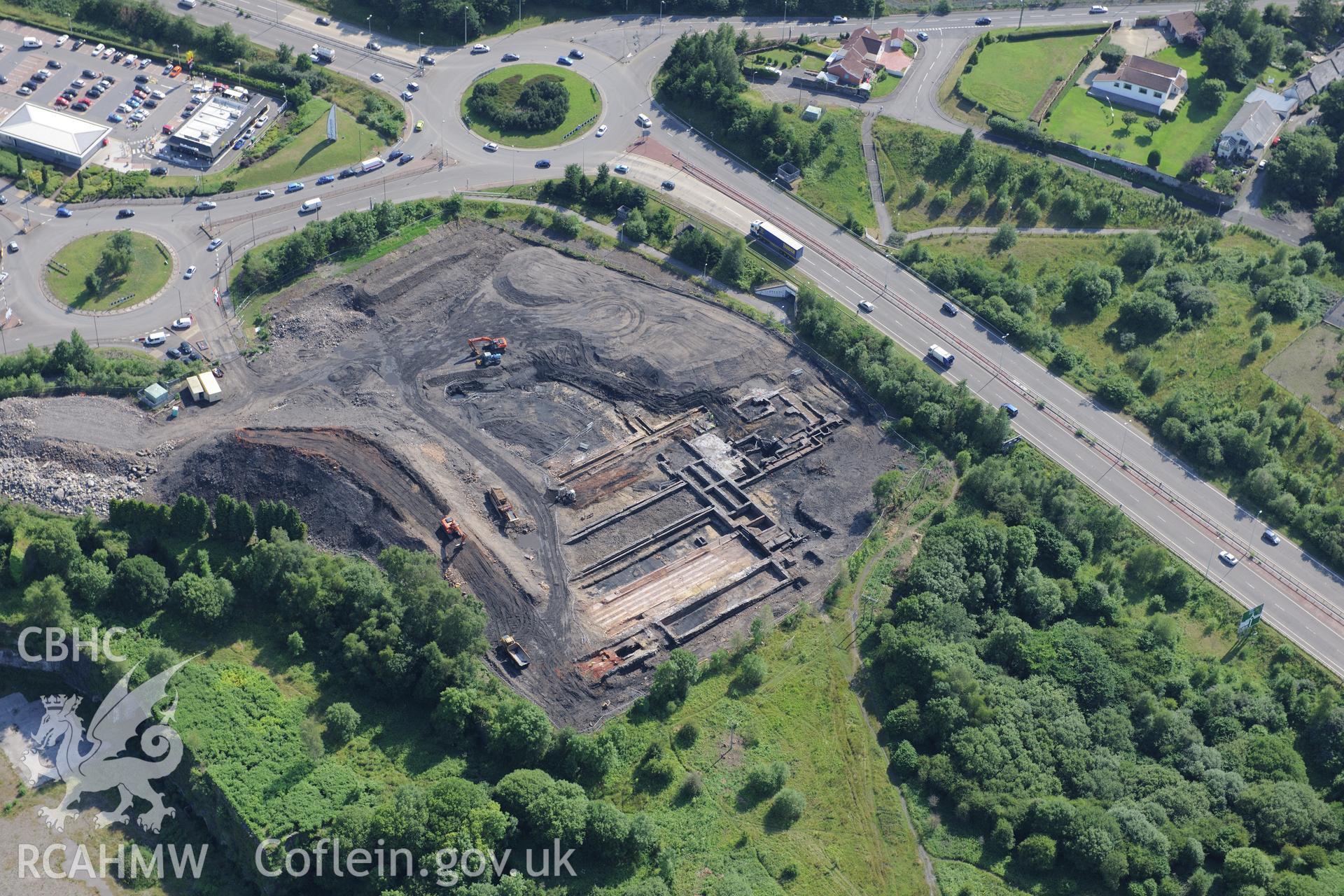 Site of former Rotax factory, and Cyfarthfa Ironworks including the remains of its blast furnaces, under excavation by Glamorgan-Gwent Archaeological Trust. Oblique aerial photograph taken during the Royal Commission?s programme of archaeological aerial reconnaissance by Toby Driver on 1st August 2013.