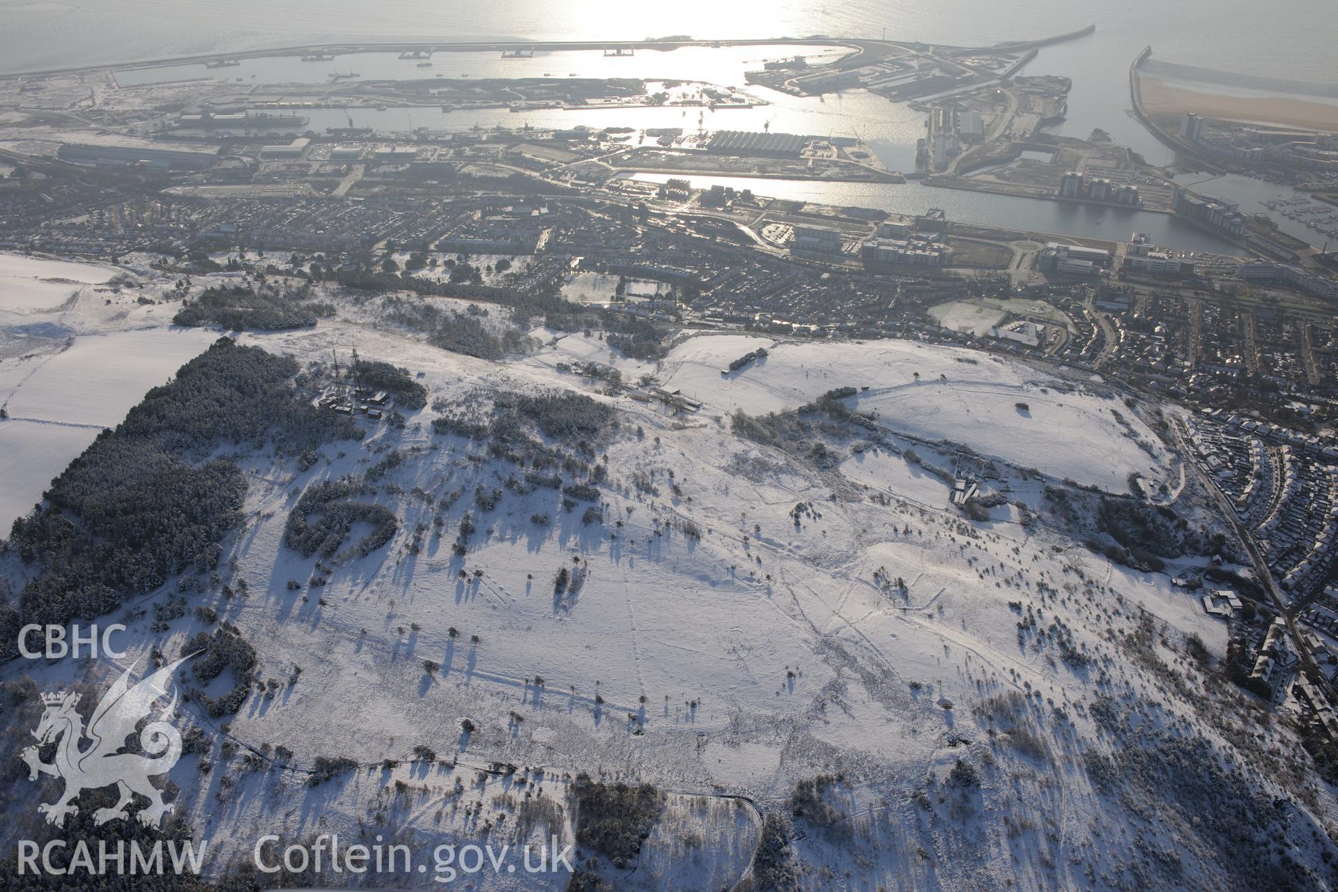 Kilvey Hill anti-glider trenches, with the King's Dock and Prince's Dock of Swansea Docks beyond. Oblique aerial photograph taken during the Royal Commission?s programme of archaeological aerial reconnaissance by Toby Driver on 24th January 2013.