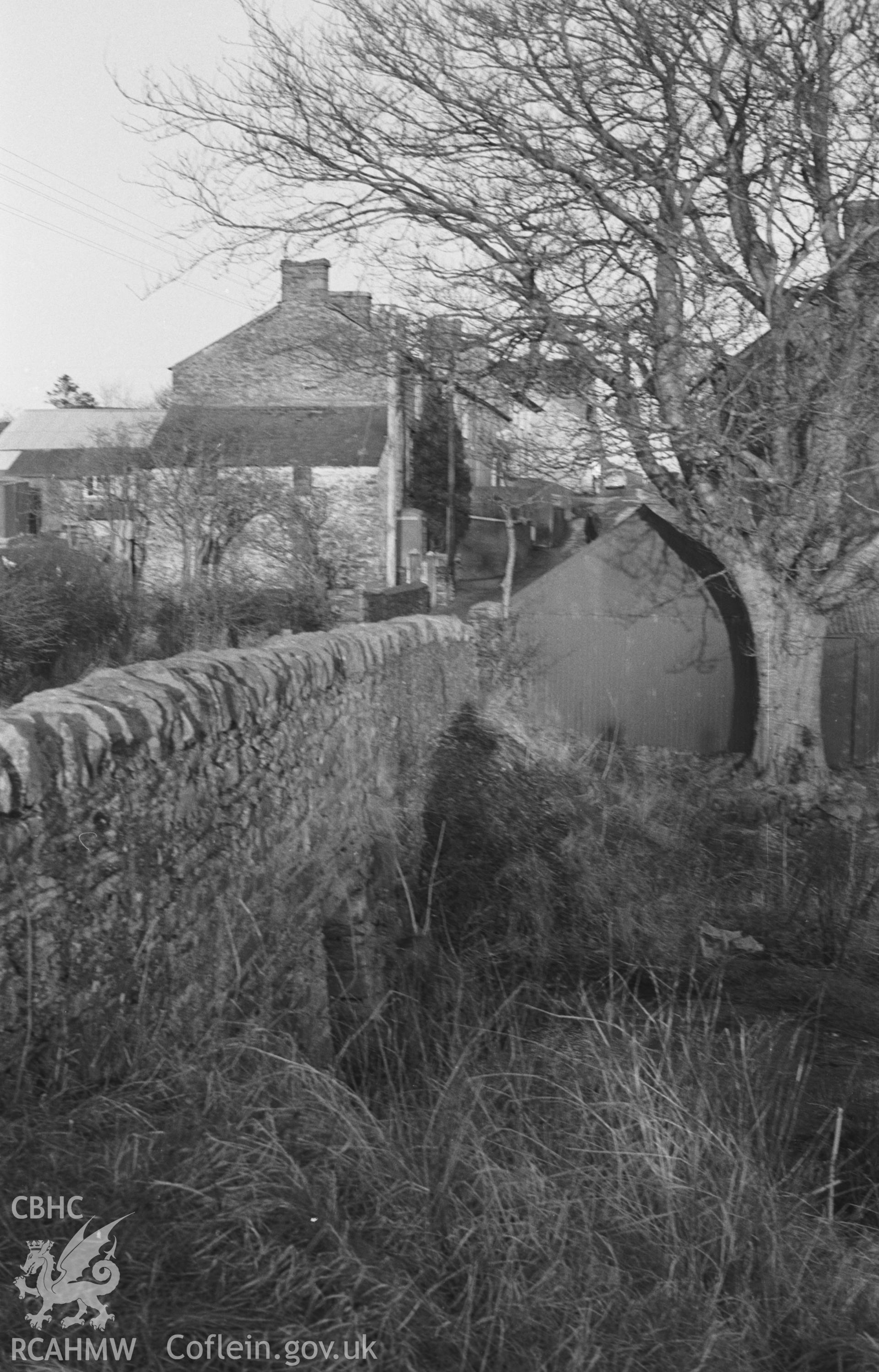 Digital copy of a black and white negative showing view looking into the village of Swyddffynnon from the downstream side of the west bridge. Photographed in December 1963 by Arthur O. Chater from Grid Reference SN 6919 6623, looking north east.