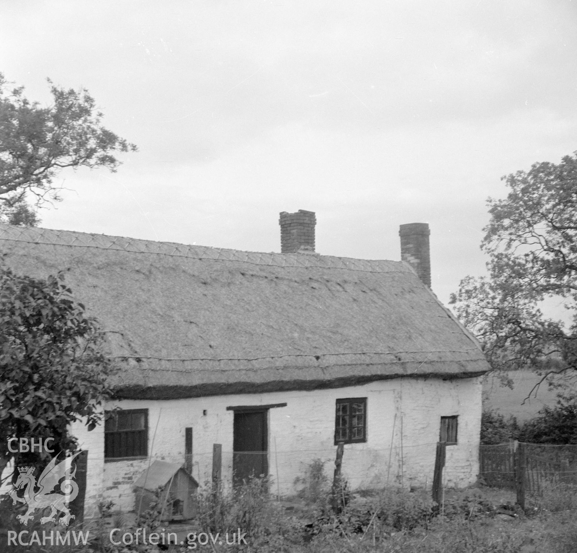 Digital copy of a nitrate negative showing an exterior view of a cruck house at Northop, Flintshire.