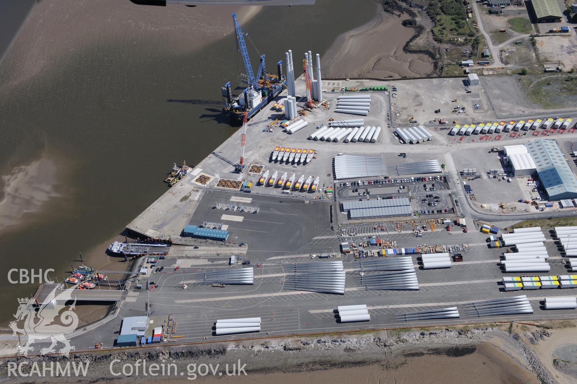 Mostyn Quay in the port of Mostyn, with windfarm parts, and Pill Box II, Whitford. Oblique aerial photograph taken during the Royal Commission?s programme of archaeological aerial reconnaissance by Toby Driver on 22nd May 2013.