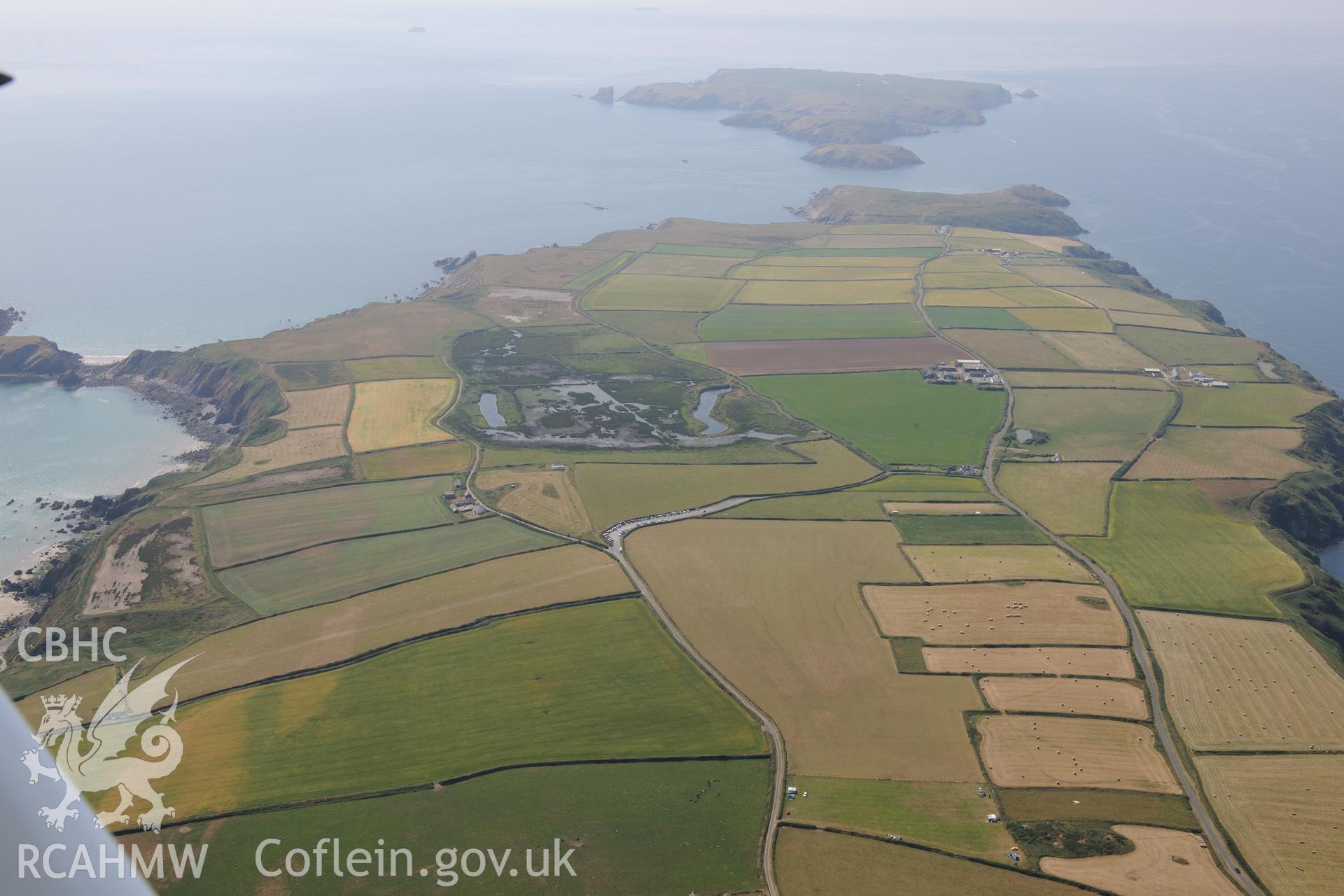 Trehill Farm defended enclosure, with the settlements and field systems on Skomer Island beyond. Oblique aerial photograph taken during the Royal Commission?s programme of archaeological aerial reconnaissance by Toby Driver on 16th July 2013.