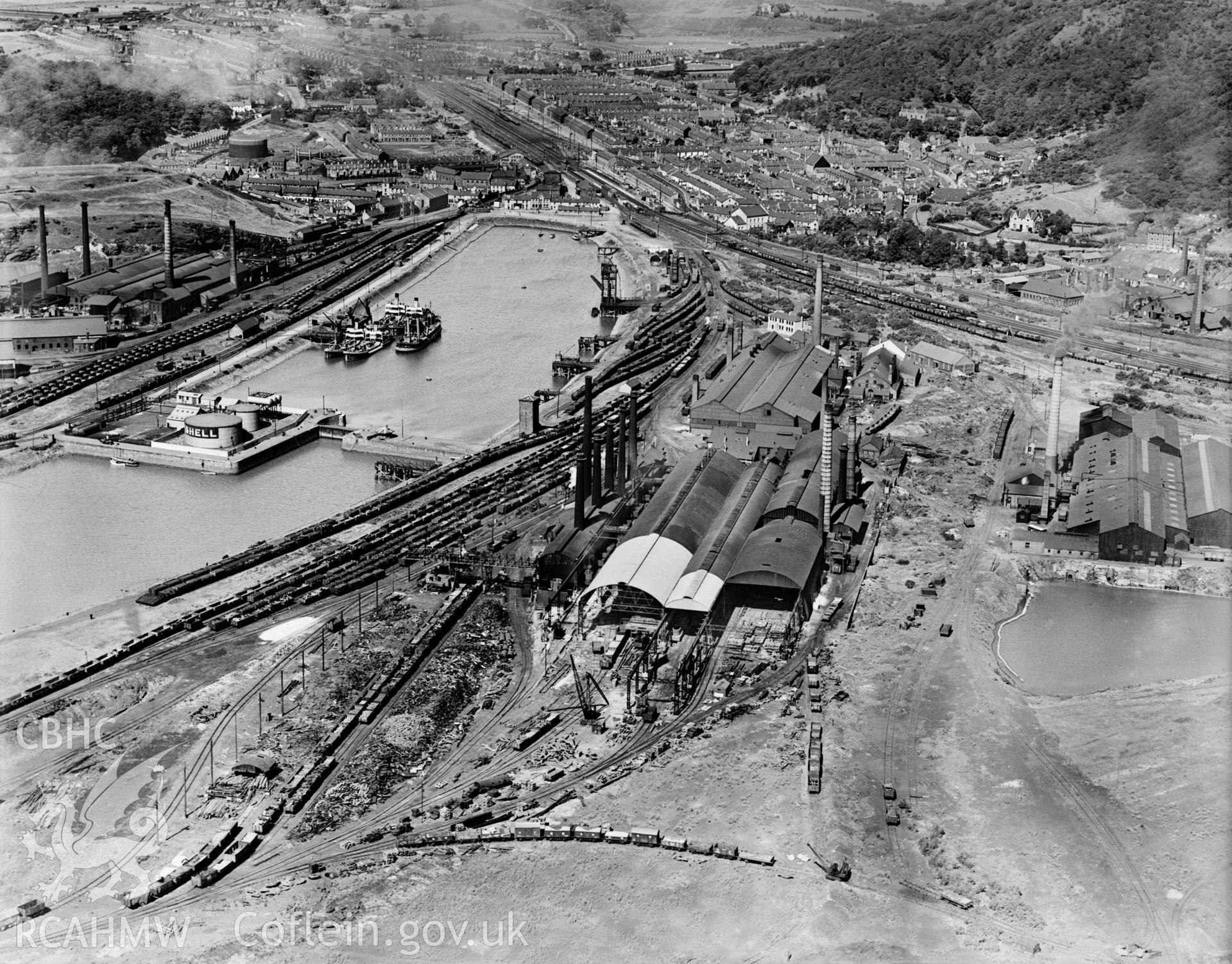 View of Briton Ferry Dock showing Baglan Bay Tinplate Co., Briton Ferry Steel Works, Albion Steelworks and Whitford Works from the south, oblique aerial view. 5?x4? black and white glass plate negative.