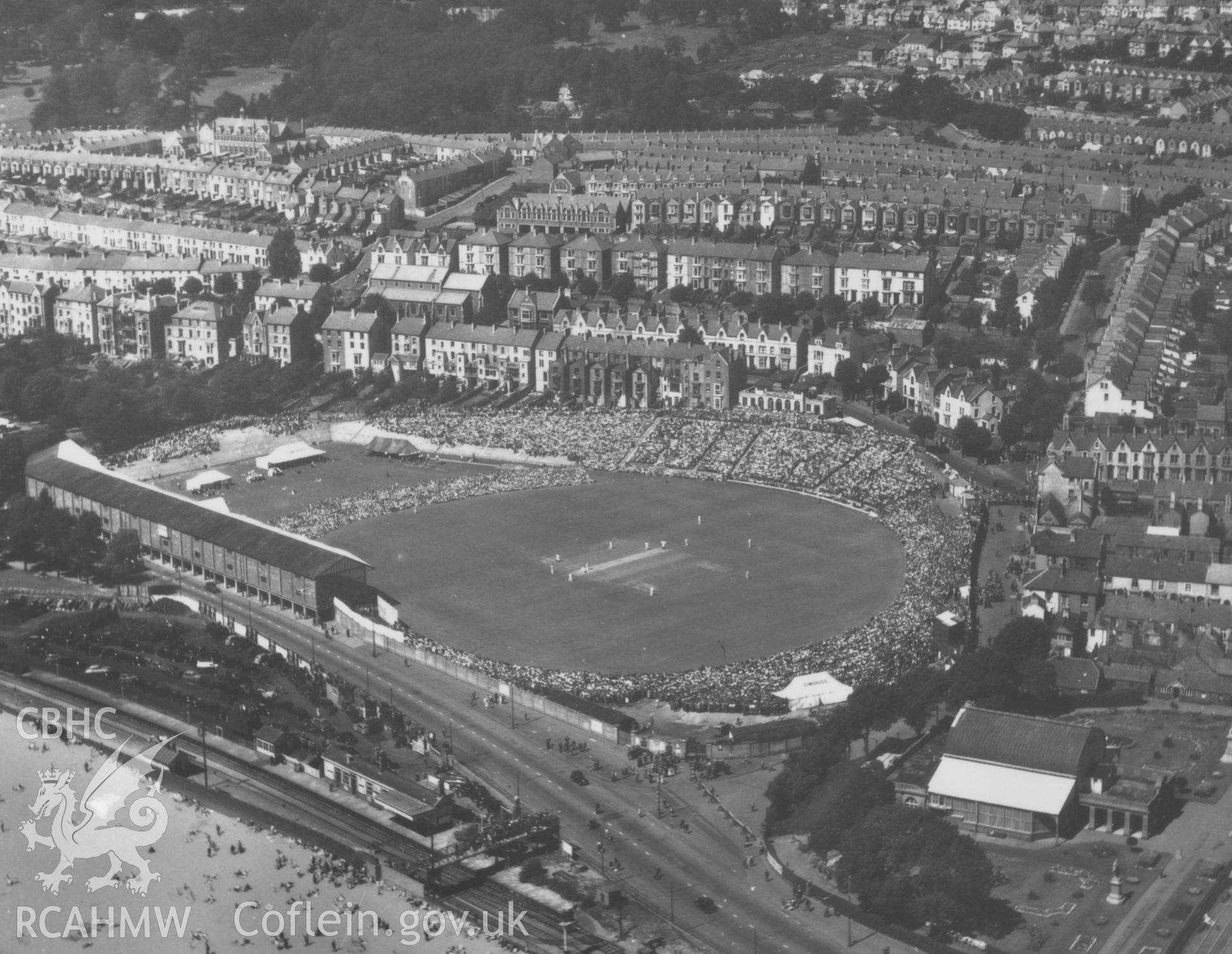 Black and white oblique aerial photograph showing St Helen's Cricket Ground, Swansea, during a Glamorgan v West Indies match, taken by Aerofilms Ltd and dated 7th August 1950.