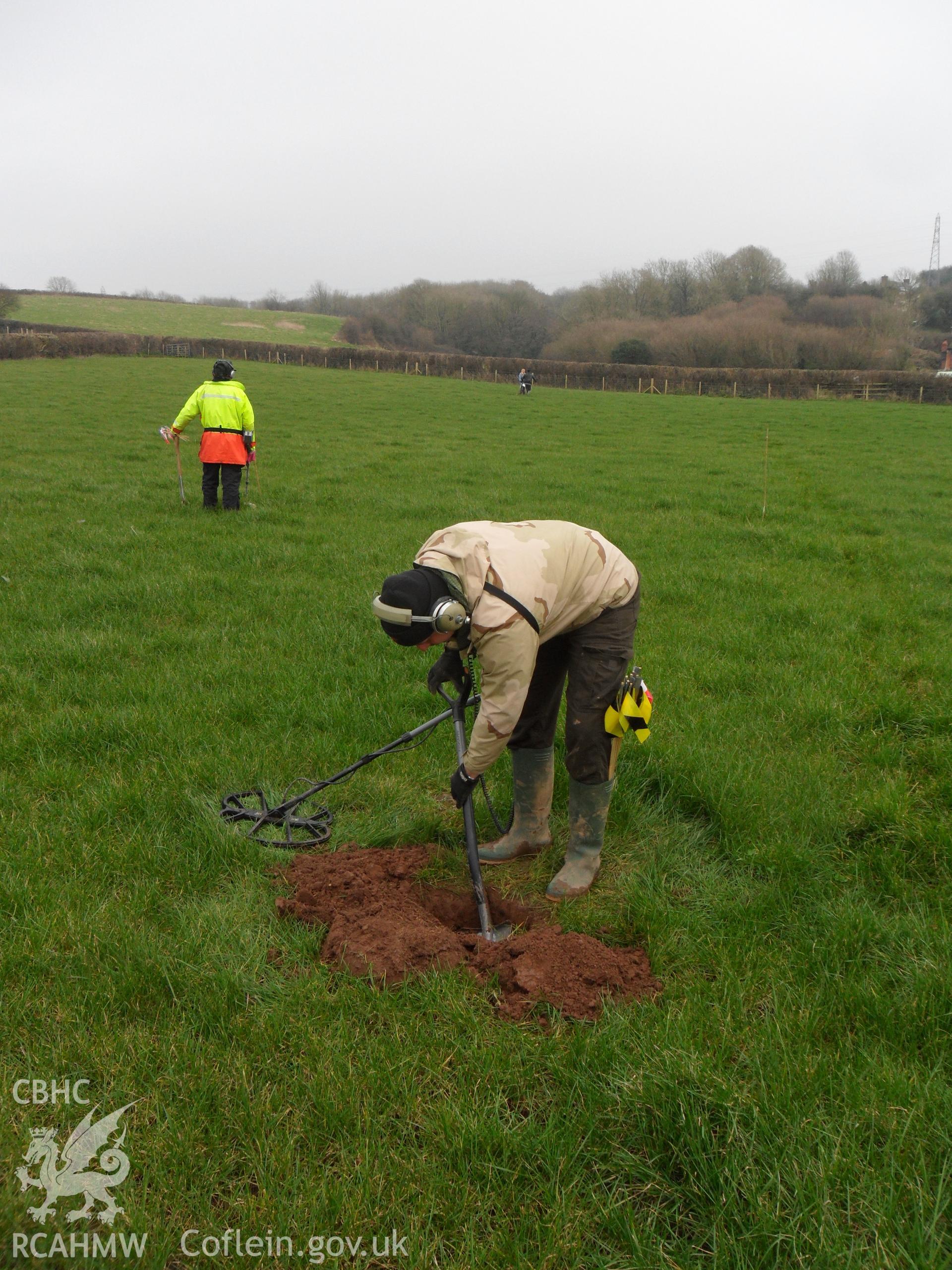 Digital colour photograph of small excavation at Maes Gwenllian battlefield. From report no. 1050 - Maes Gwenllian battlefield, part of the Welsh Battlefield Metal Detector Survey, carried out by Archaeology Wales.