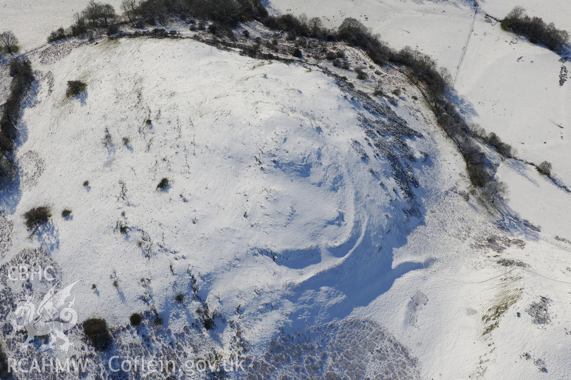 Caer Einon hillfort and three hut platforms, north east of Builth Wells. Oblique aerial photograph taken during the Royal Commission?s programme of archaeological aerial reconnaissance by Toby Driver on 15th January 2013.