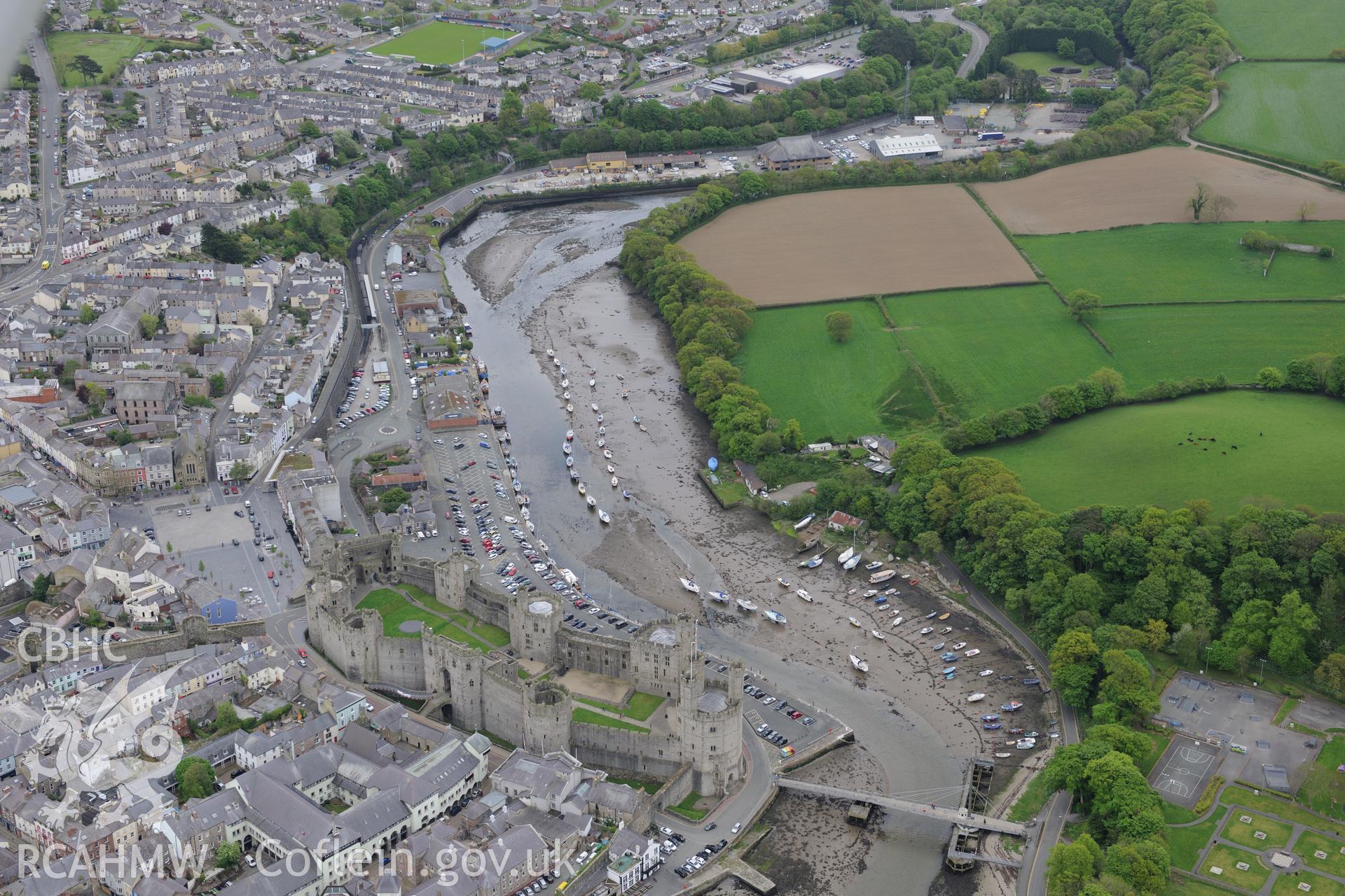 The town of Caernarfon, with the castle and the swing bridge visible. Oblique aerial photograph taken during the Royal Commission?s programme of archaeological aerial reconnaissance by Toby Driver on 22nd May 2013.