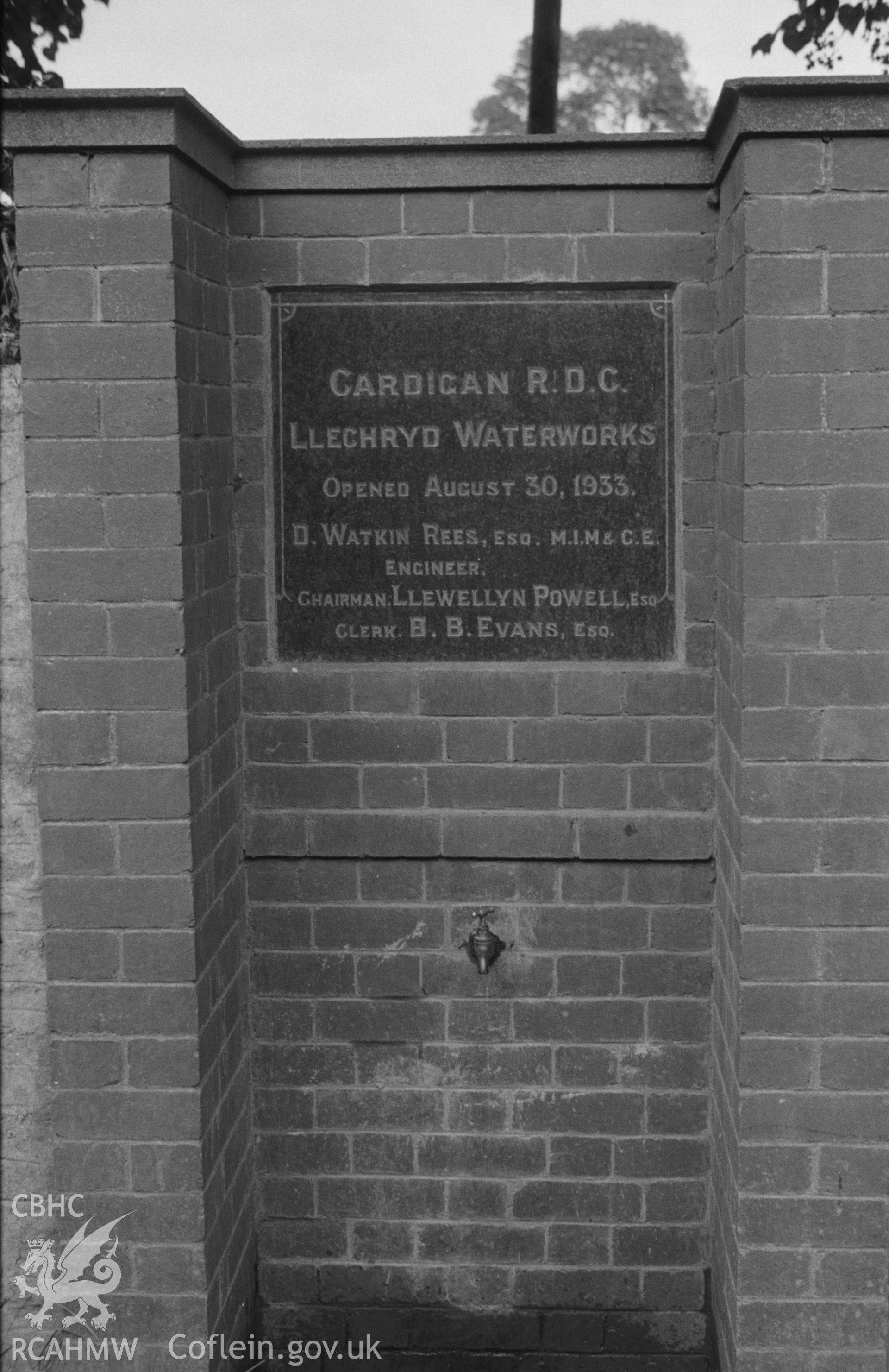 Digital copy of black & white negative showing plaque to commemorate opening of waterworks at Llechryd in 1933, above tap on the Cardigan road. Photographed by Arthur O. Chater on 11th September 1964 from Grid Reference SN 217 438, looking north east.