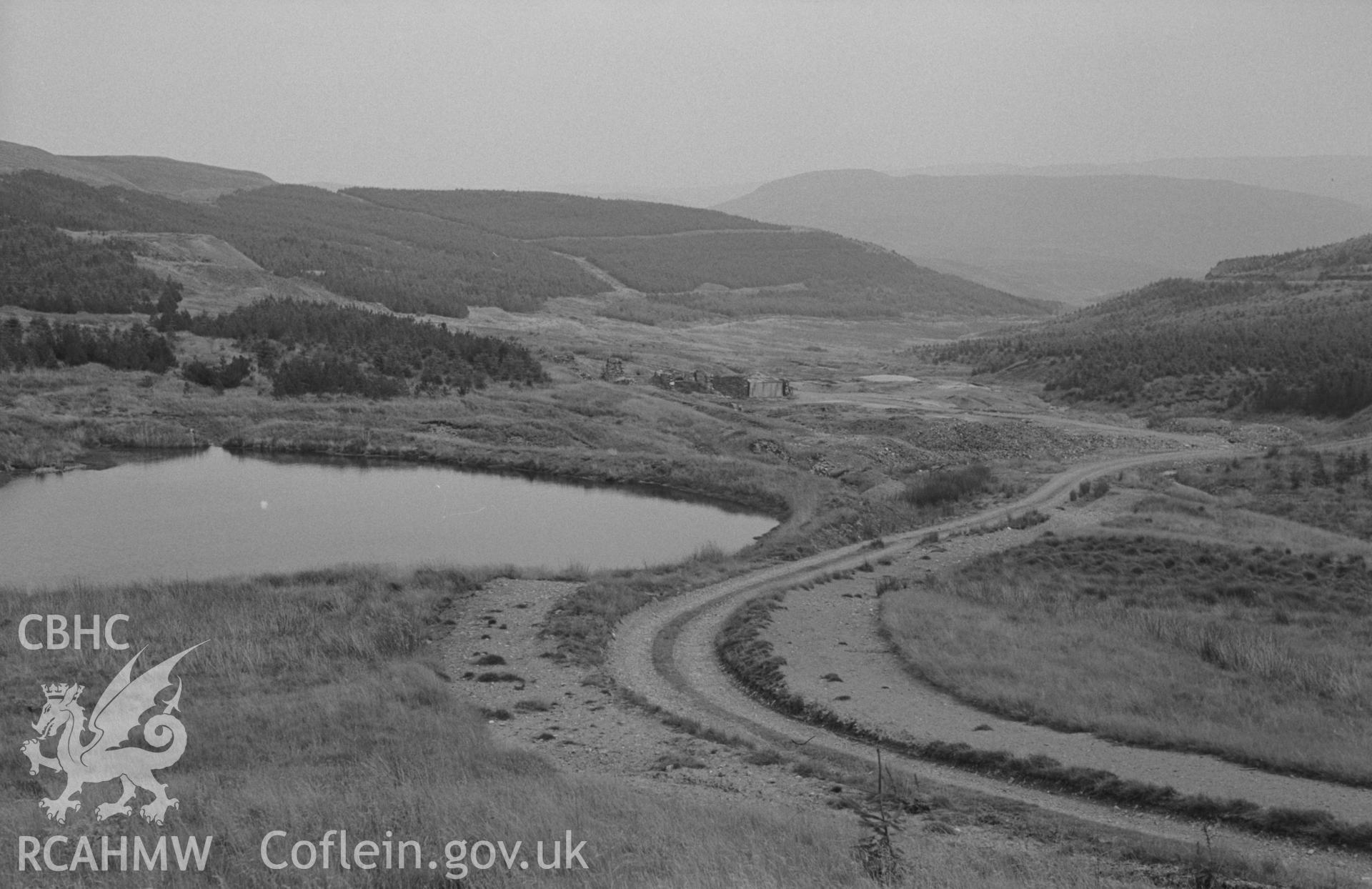 Digital copy of a black and white negative showing view looking over the reservoir to the ruins of Esgair-Fraith lead mine. Photographed by Arthur O. Chater on 22nd August 1967, looking east from Grid Reference SN 737 913.