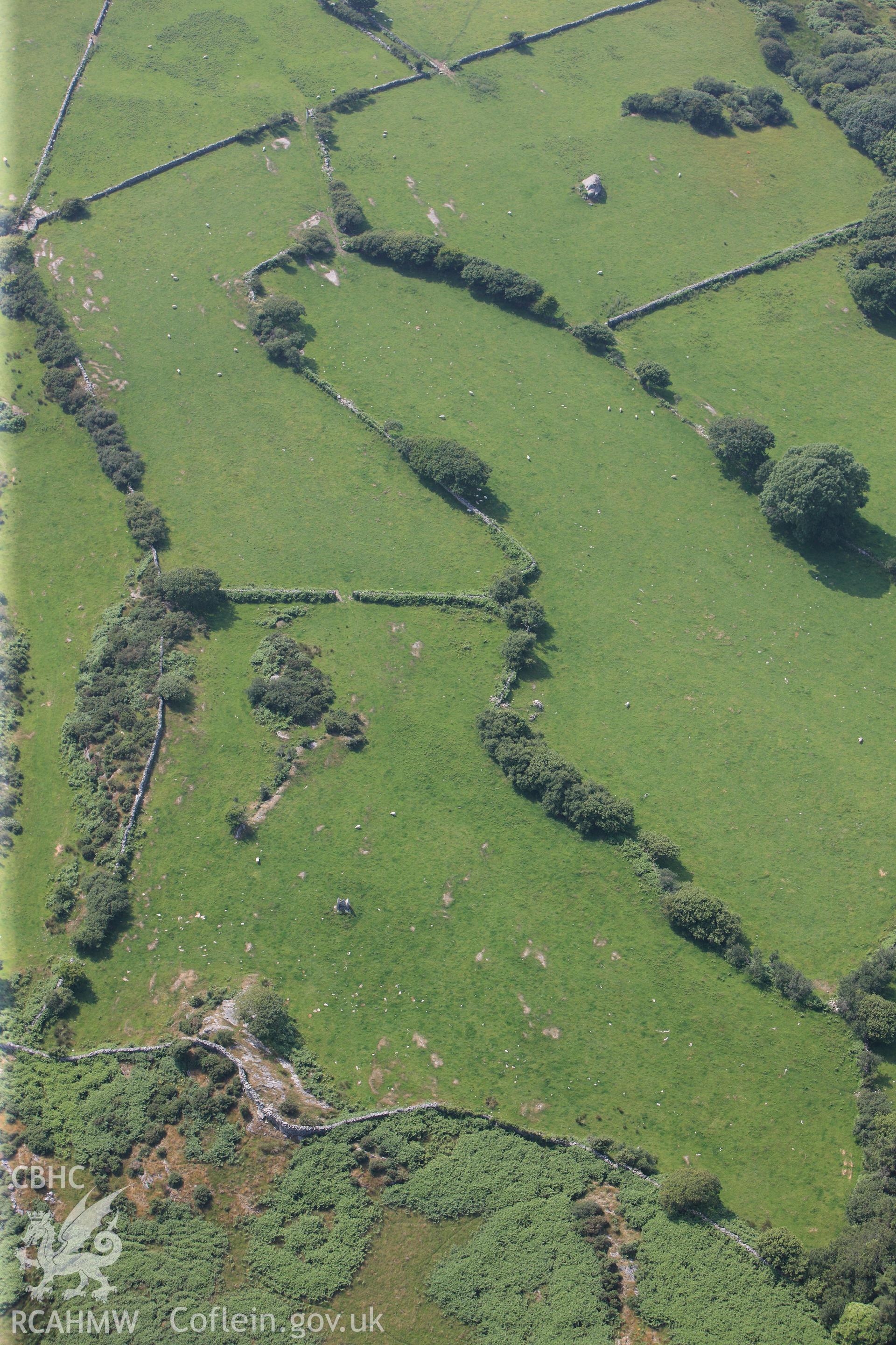 Cist Cerrig burial chamber, cup-marked outcrop and rock exposures. Oblique aerial photograph taken during the Royal Commission?s programme of archaeological aerial reconnaissance by Toby Driver on 12th July 2013.