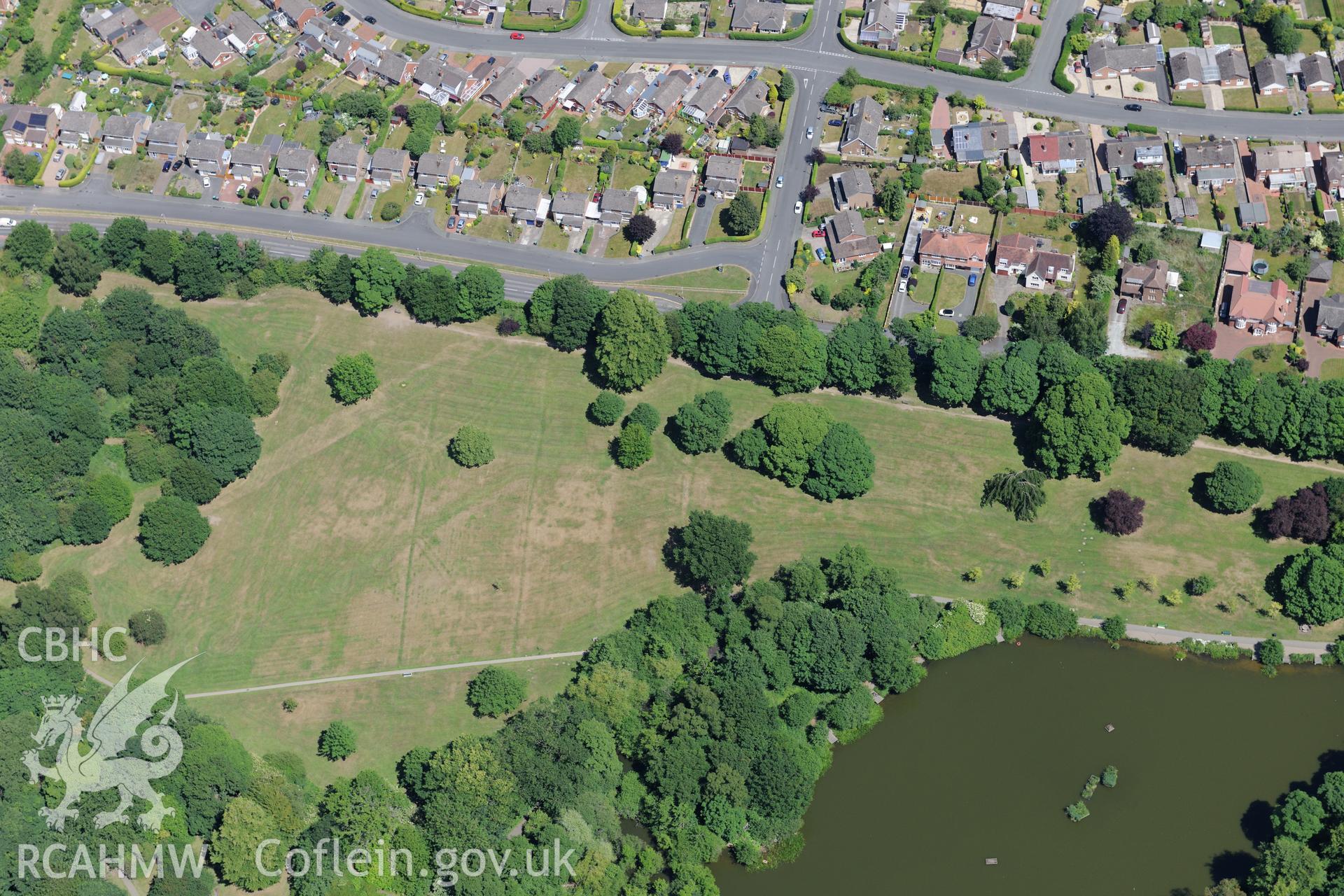 Acton Park and the barrow at Acton Park, with Wrexham beyond. Oblique aerial photograph taken during the Royal Commission's programme of archaeological aerial reconnaissance by Toby Driver on 30th June 2015.