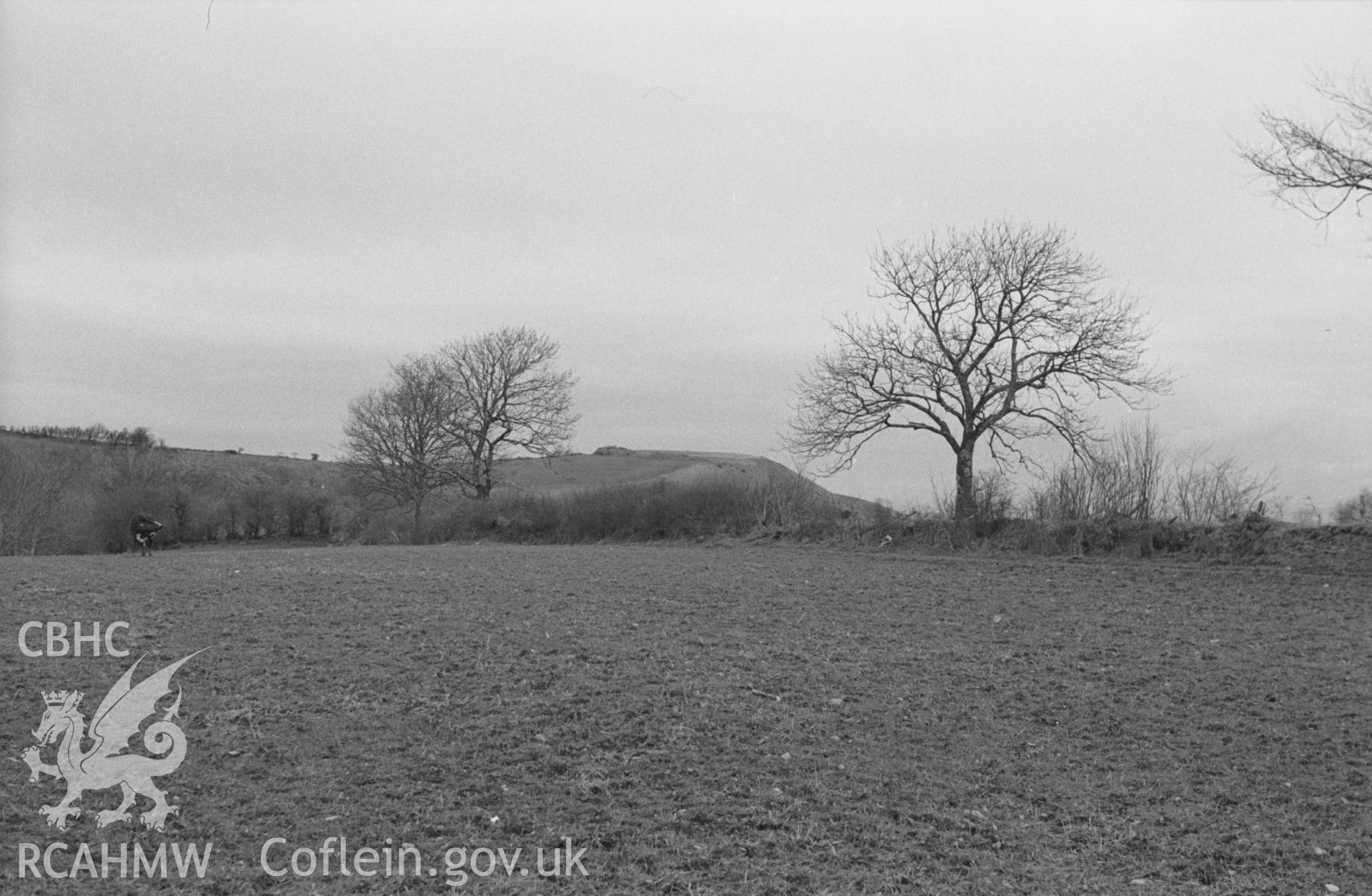 Digital copy of a black and white negative showing Castell Moeddyn-Fach from the fields west of Blaenaugwenog. Photographed by Arthur O. Chater in April 1965 from Grid Reference SN 475 513, looking east north east.