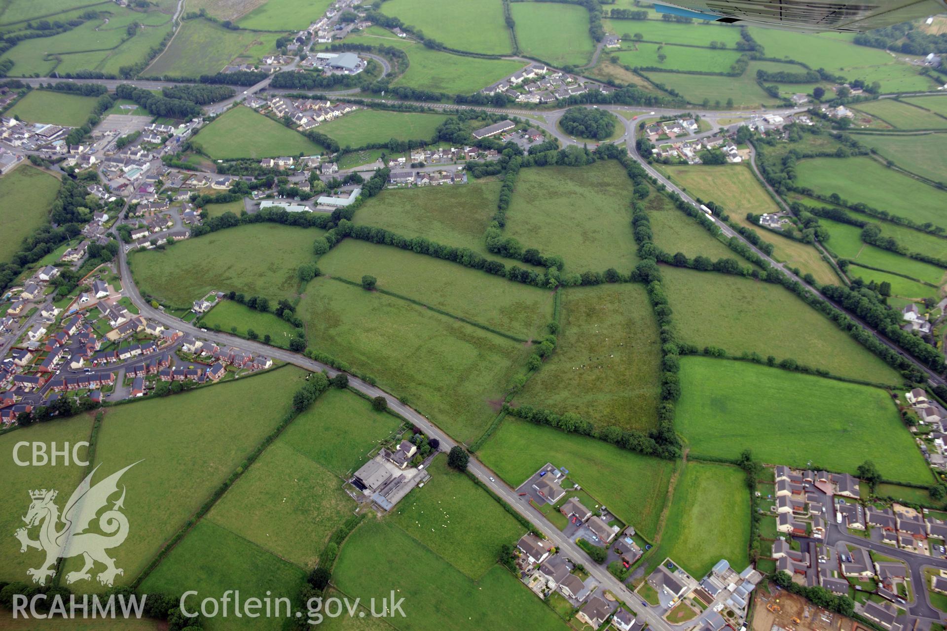 Ostrey St. Clears defended enclosure or fortlet, within the surrounding village of St. Clears, west of Carmarthen. Oblique aerial photograph taken during the Royal Commission?s programme of archaeological aerial reconnaissance by Toby Driver on 1st August 2013.