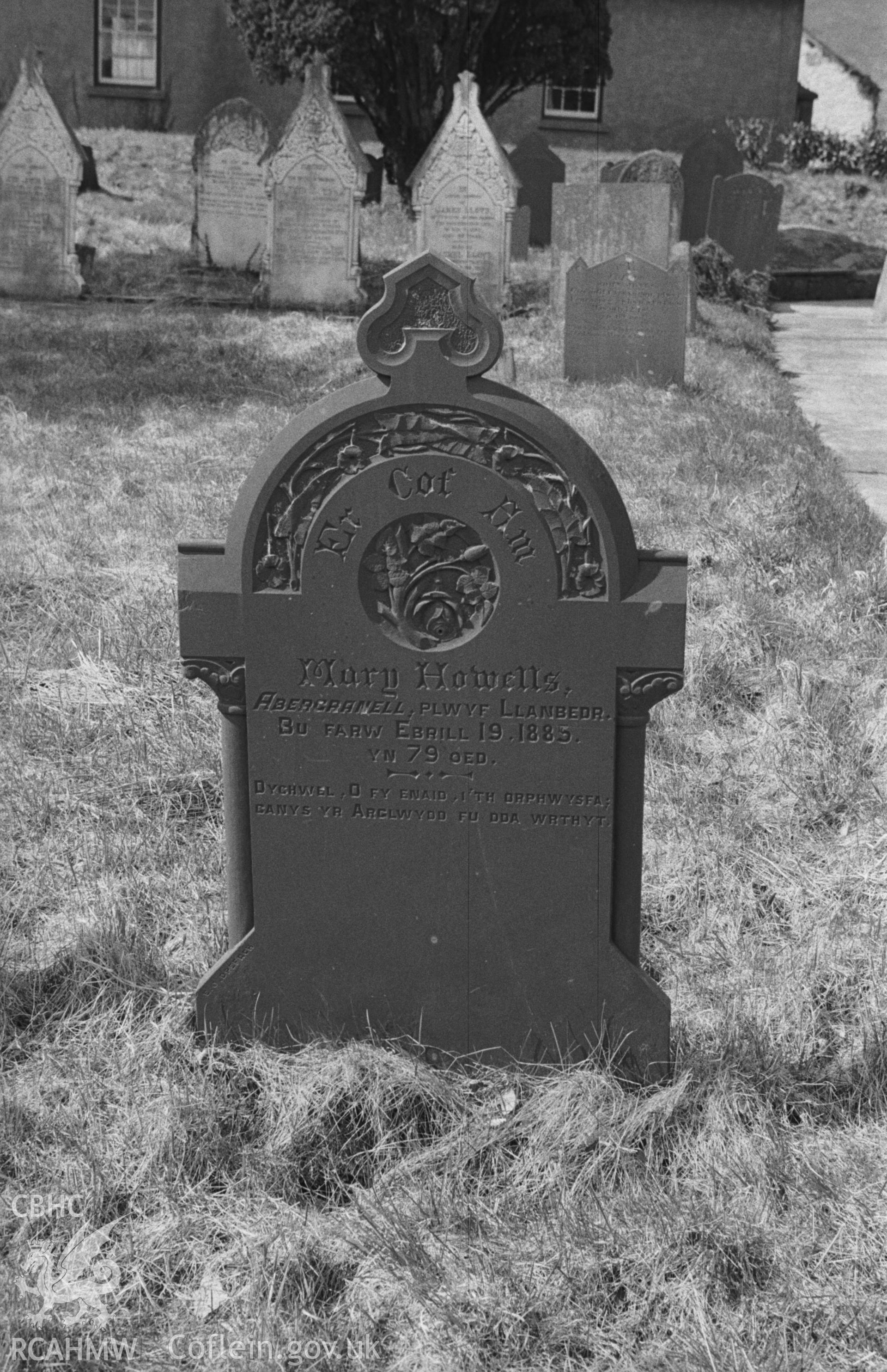 Digital copy of black and white negative showing Mary Howell's tombstone (d. 1885) in St Gwynin's churchyard to the south of the church, with Calystegia motif for decoration. Photographed in April 1963 by Arthur O. Chater from Grid Reference SN 5332 4725.