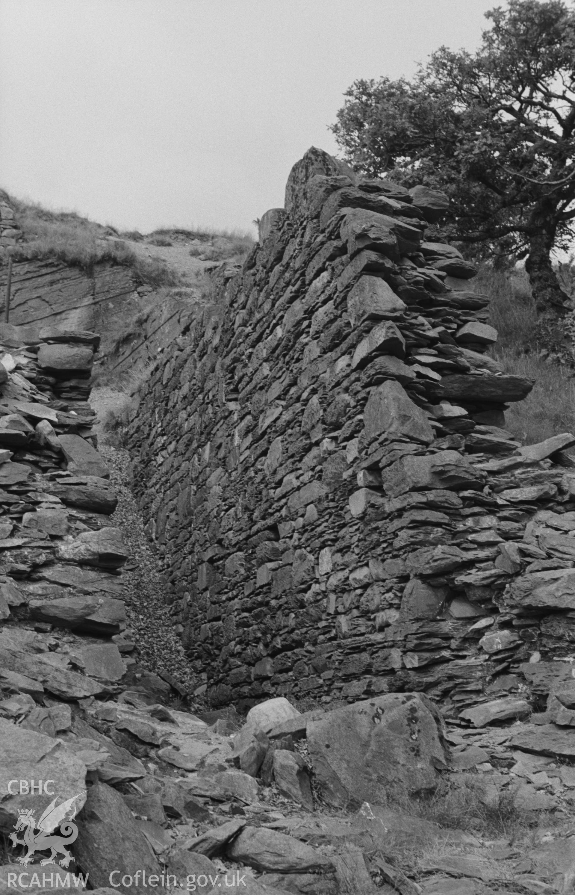 Digital copy of a black and white negative showing wall of (?)wheel pit of Abbey Consols mine. Photographed by Arthur O. Chater on 25th August 1967, looking north north east from Grid Reference SN 743 662.