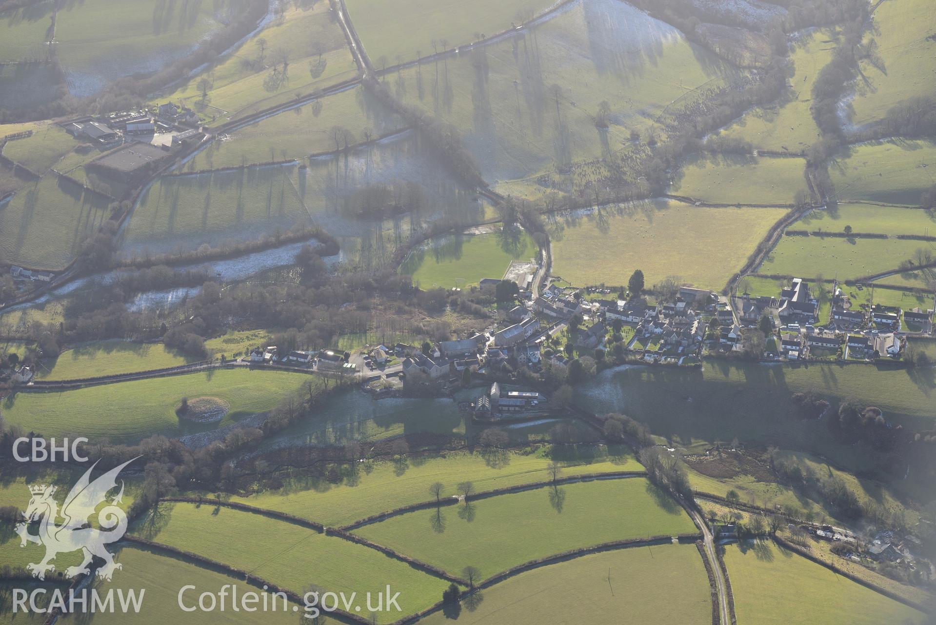 Castell Mawr motte and bailey and the village of Llanboidy, north west of Carmarthen. Oblique aerial photograph taken during the Royal Commission's programme of archaeological aerial reconnaissance by Toby Driver on 4th February 2015.