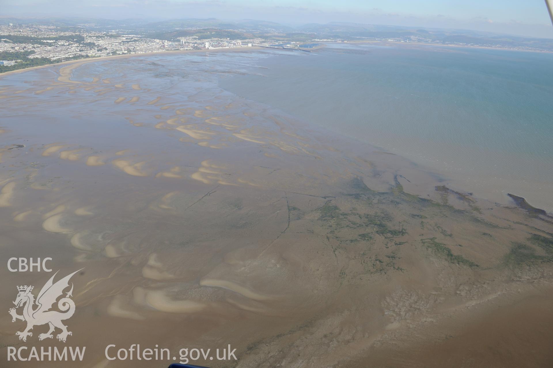 Fishtraps in Swansea Bay with the city of Swansea beyond. Oblique aerial photograph taken during the Royal Commission's programme of archaeological aerial reconnaissance by Toby Driver on 30th September 2015.