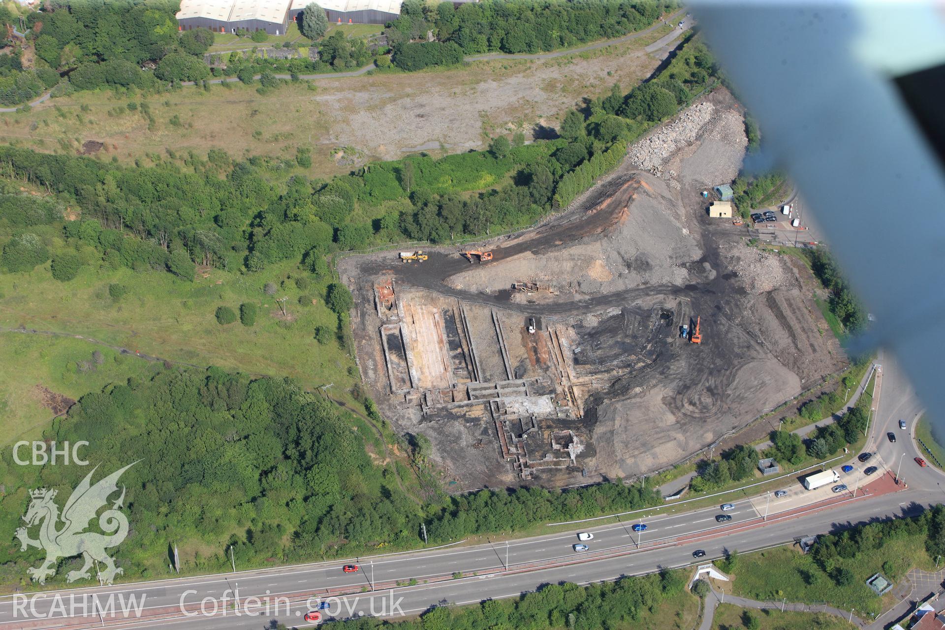 Site of former Rotax factory, and Cyfarthfa Ironworks including the remains of its blast furnaces, under excavation by Glamorgan-Gwent Archaeological Trust. Oblique aerial photograph taken during the Royal Commission?s programme of archaeological aerial reconnaissance by Toby Driver on 1st August 2013.