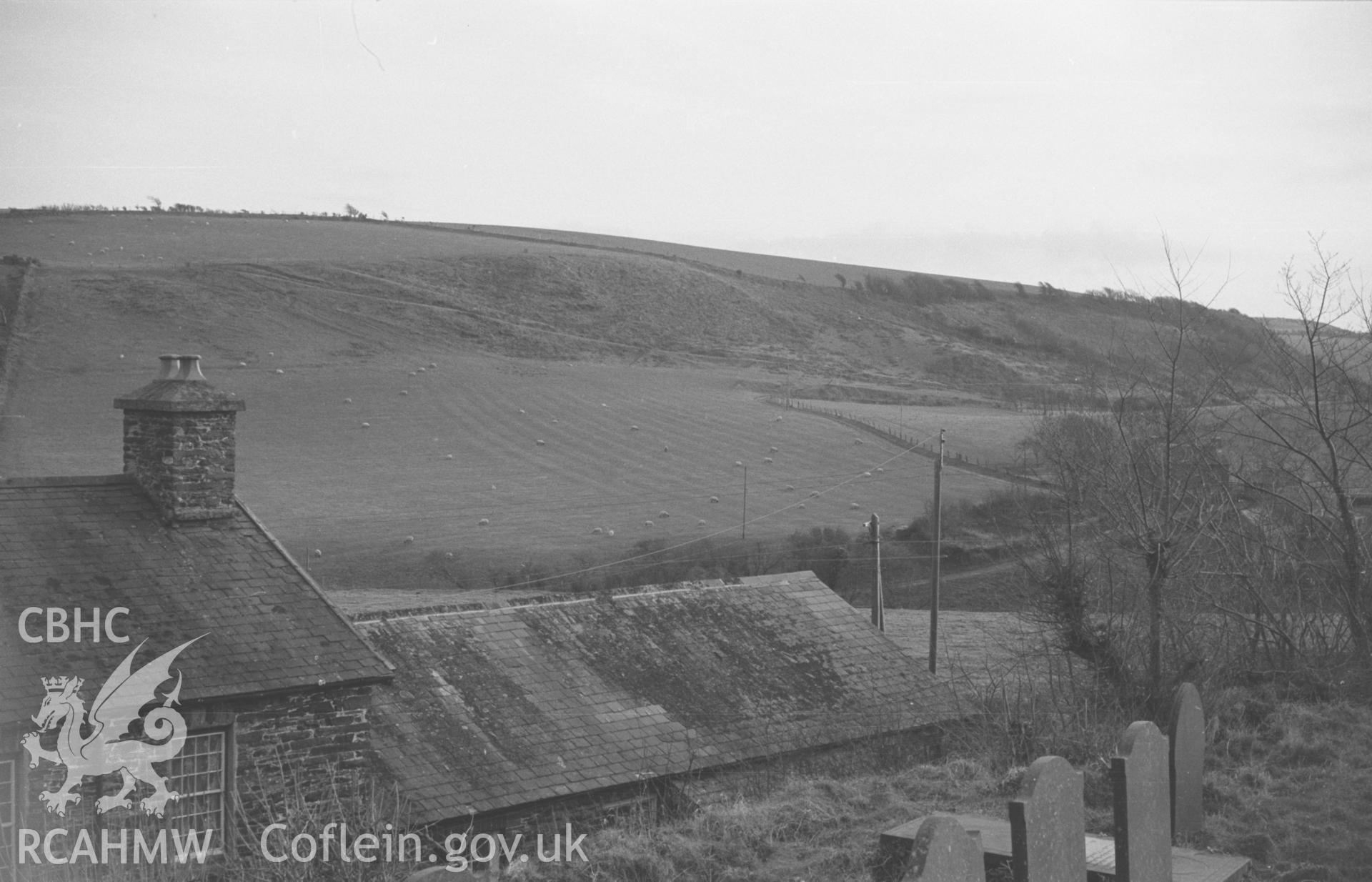 Digital copy of black & white negative showing view looking south south east over the school from St. Deinionl's churchyard, showing ridge & furrow (at c. SN 5617 7188) in sloping field near Llanddeiniol. Photographed in December 1963 by Arthur O. Chater.