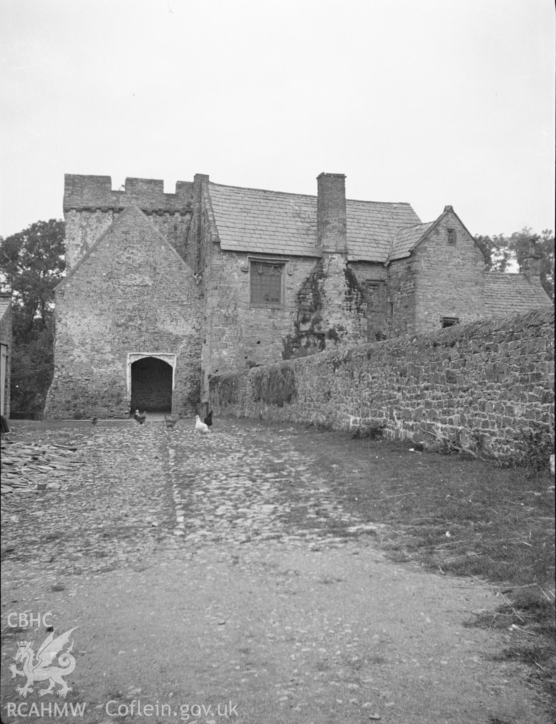 Digital copy of a nitrate negative showing exterior view of Penhow Castle - used as a farmhouse and farm buildings. From the National Building Record Postcard Collection.