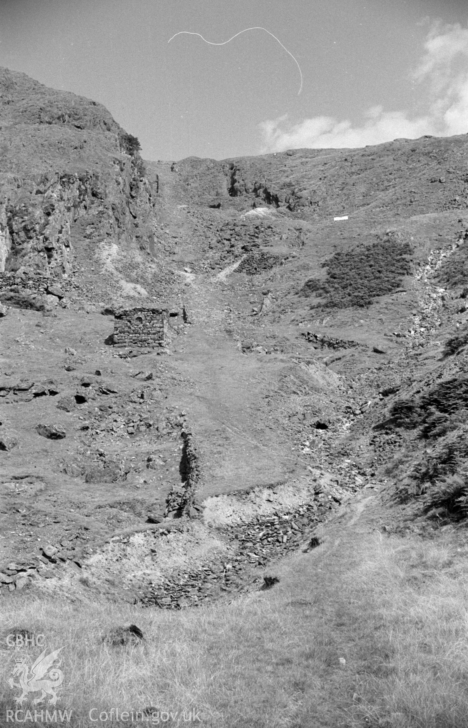 Digital copy of black & white negative looking along track of Plynlimon and Hafan Tramway and up the incline, with mine ruins in centre (wheelpit to left of centre). Photograph by Arthur O. Chater, August 1965, from Grid Ref SN 7273 8792, looking east.