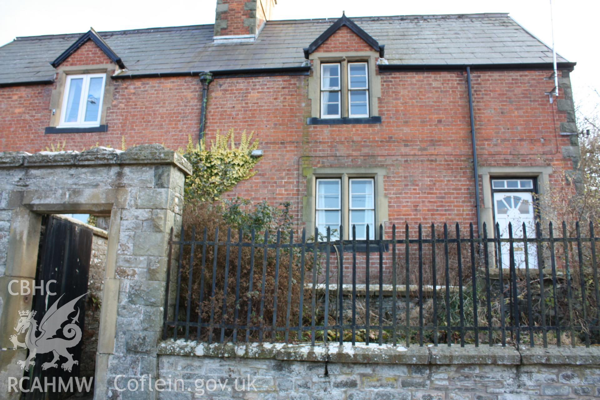 Colour photograph showing red brick exterior, stone garden wall with iron railings and wooden door to garden at Pentre Cottages, Leighton. Photographed during survey conducted by Geoff Ward on 11th July 2009.