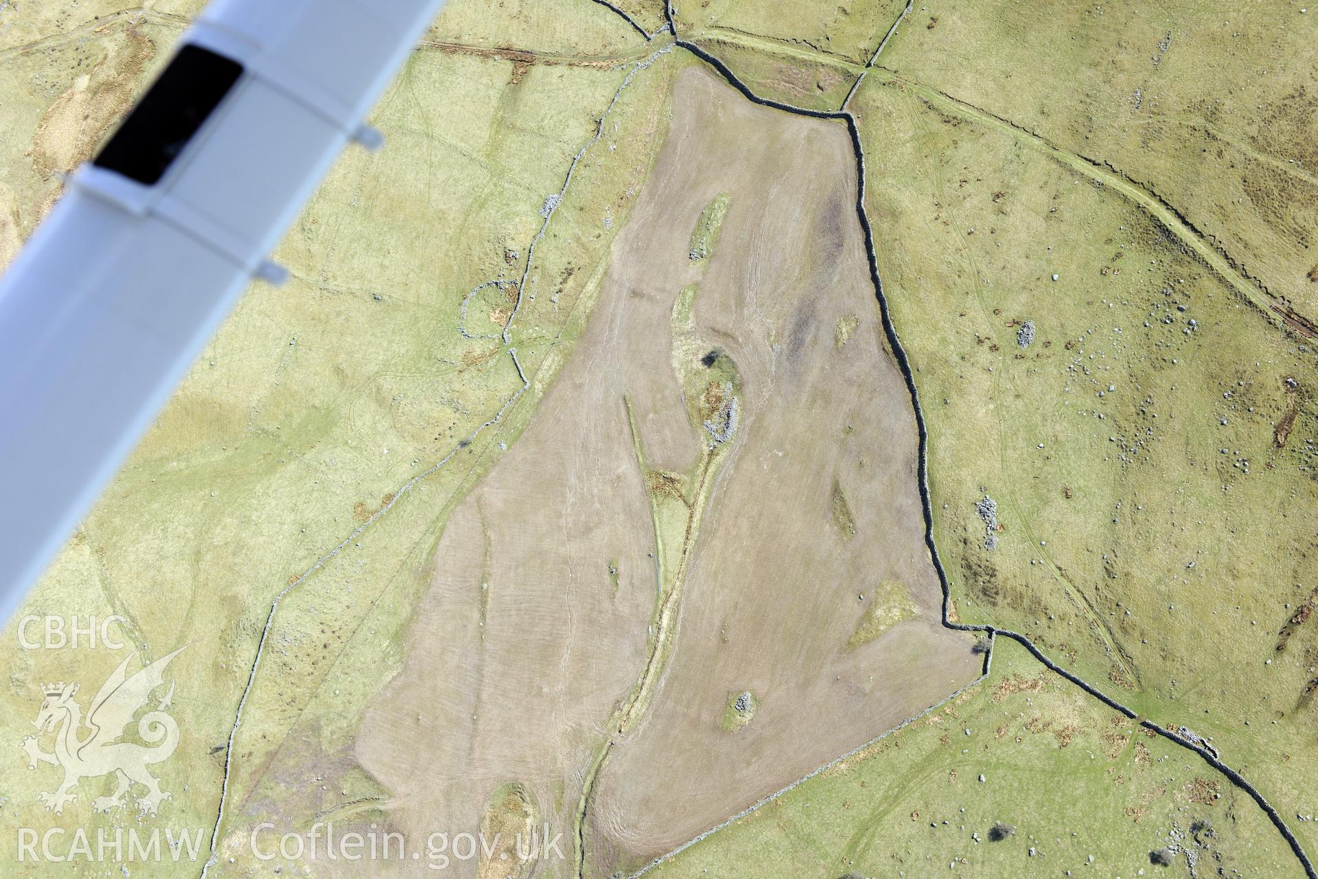 Ffridd Fedw round hut, enclosure, ancient field and kerb cairn, and Tyddyn Sion Wyn ring cairn, Talsarnau, north east of Harlech. Oblique aerial photograph taken during the Royal Commission?s programme of archaeological aerial reconnaissance by Toby Driver on 1st May 2013.