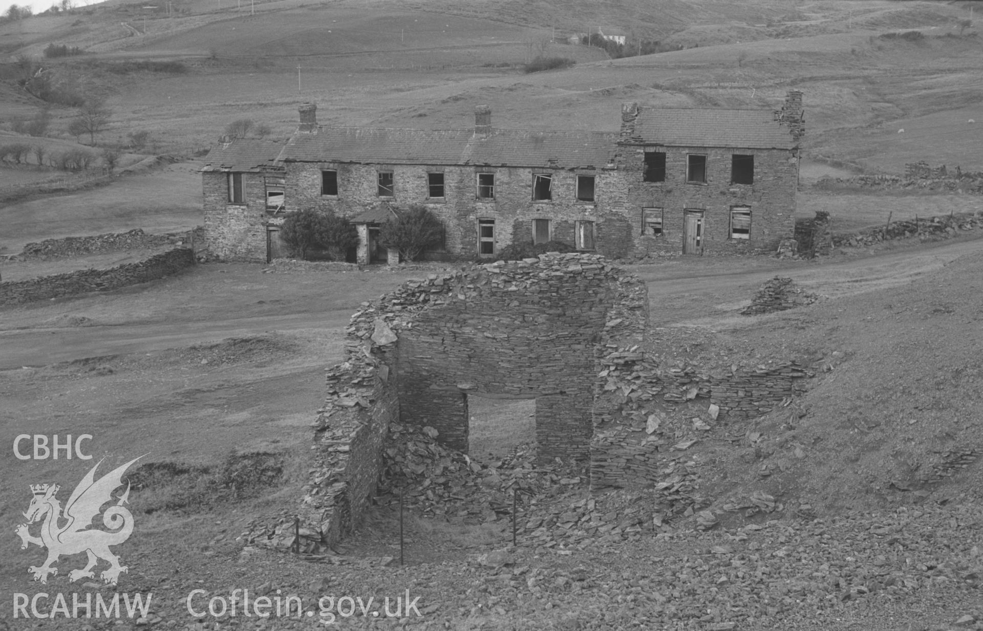 Digital copy of black & white negative showing view looking across Ty'r-Hir miners cottages, Bwlch Gwyn lead mine, Ystumtuen, with Ty-Gwyn in background. Photographed by Arthur O. Chater on 28th January 1968, looking north from Grid Reference SN 739 788.