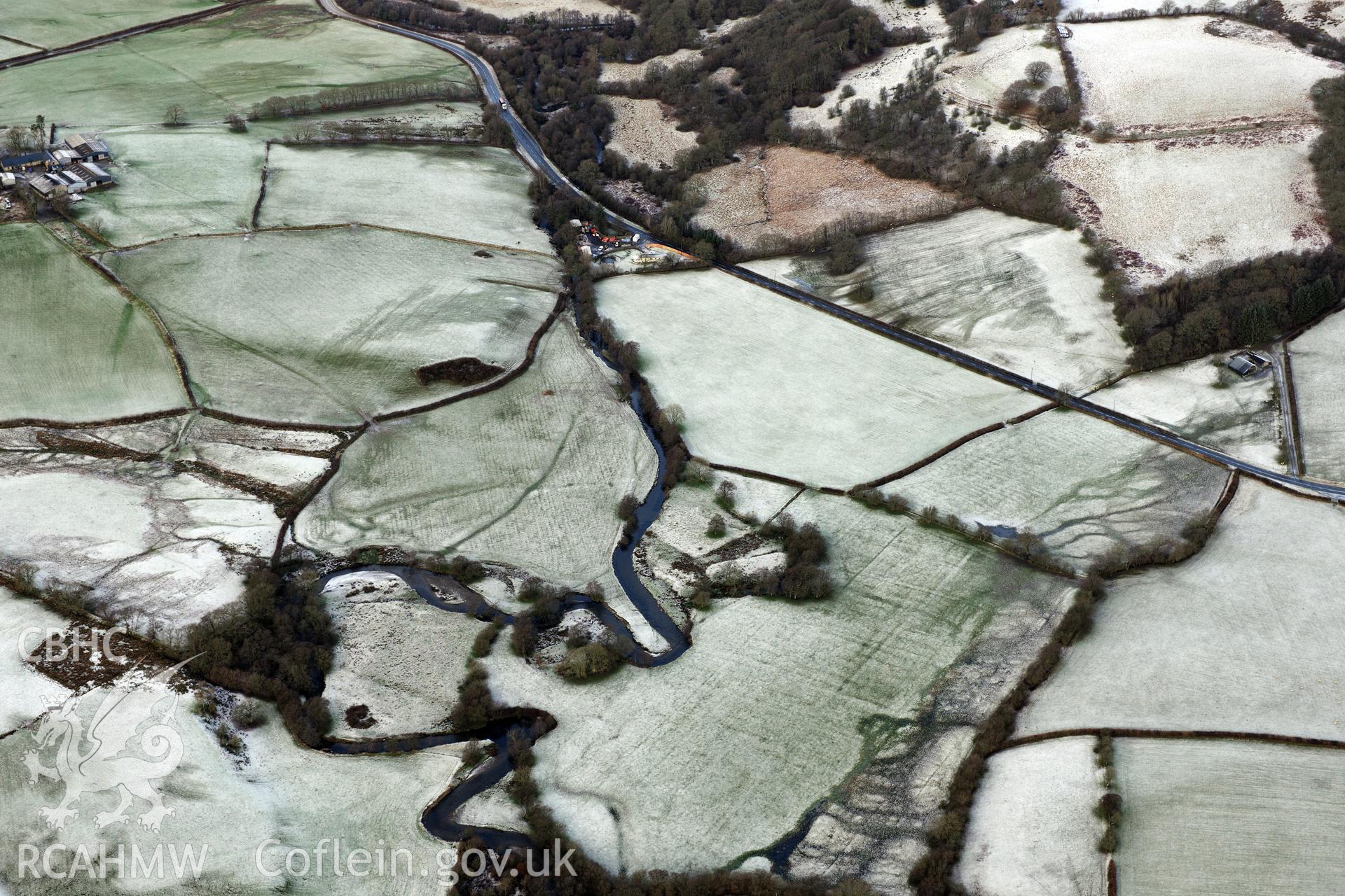 Riverside earthworks to the south-east of Caerau Roman Fort, Beulah, west of Builth Wells. Oblique aerial photograph taken during the Royal Commission?s programme of archaeological aerial reconnaissance by Toby Driver on 15th January 2013.