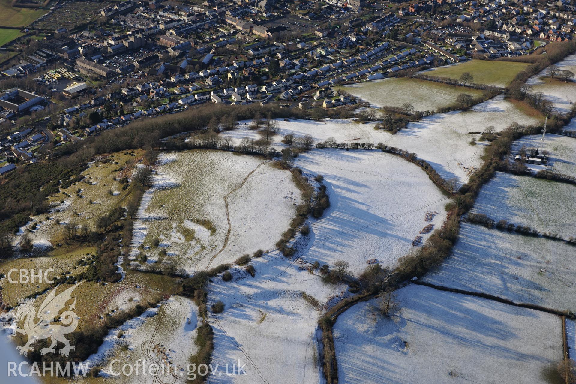 Slwch camp or Tump Hillfort and the site of St. Elenud's chapel and well, with housing in Brecon beyond. Oblique aerial photograph taken during the Royal Commission?s programme of archaeological aerial reconnaissance by Toby Driver on 15th January 2013.