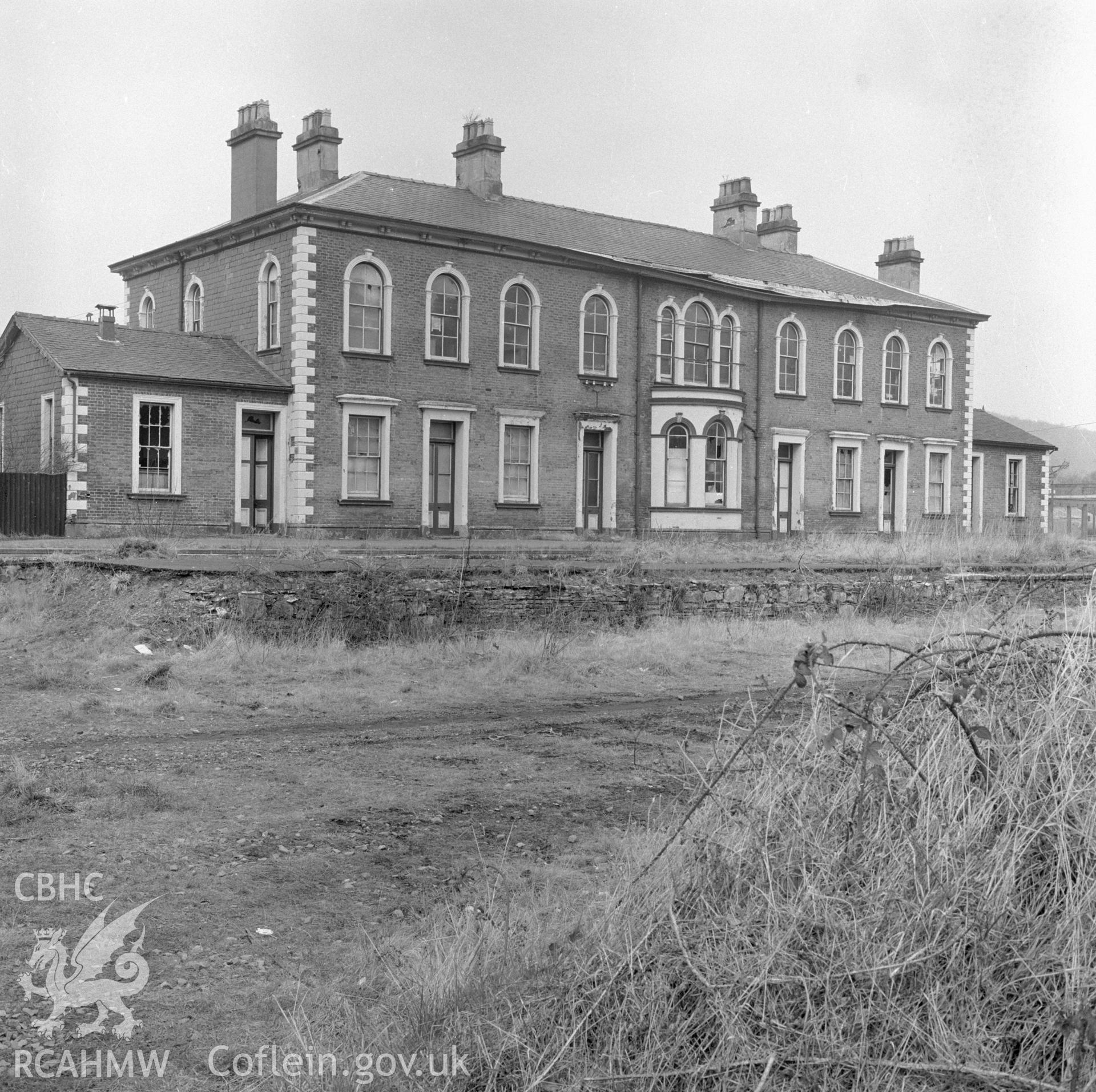 Digital copy of a black and white negative showing a view of the railtrack side elevation of Llanidloes Railway Station taken by Douglas Hague.