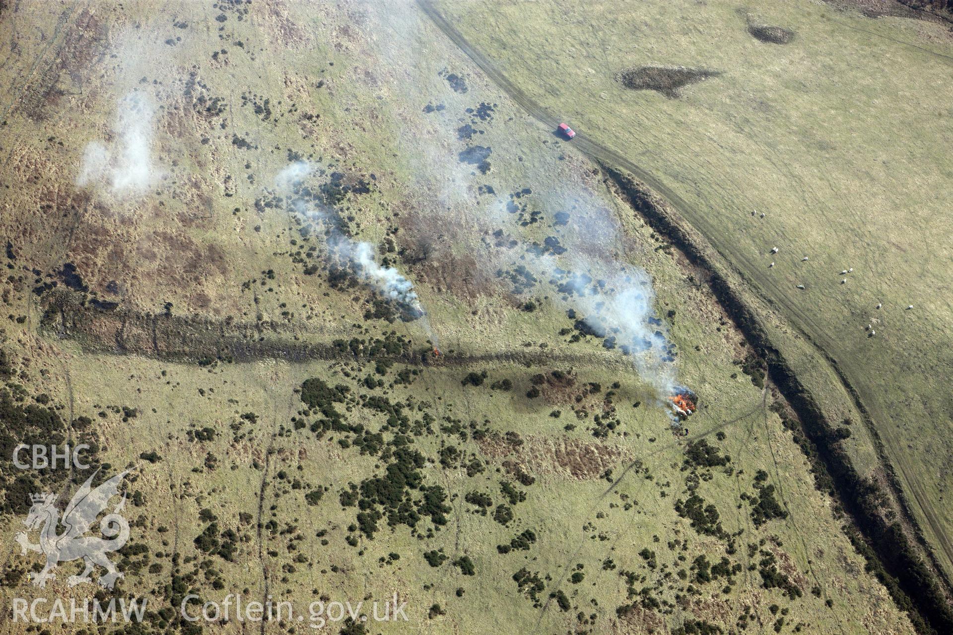 Controlled burning at Foel Fenlli Hillfort, between Ruthin and Mold. Oblique aerial photograph taken during the Royal Commission?s programme of archaeological aerial reconnaissance by Toby Driver on 28th February 2013.