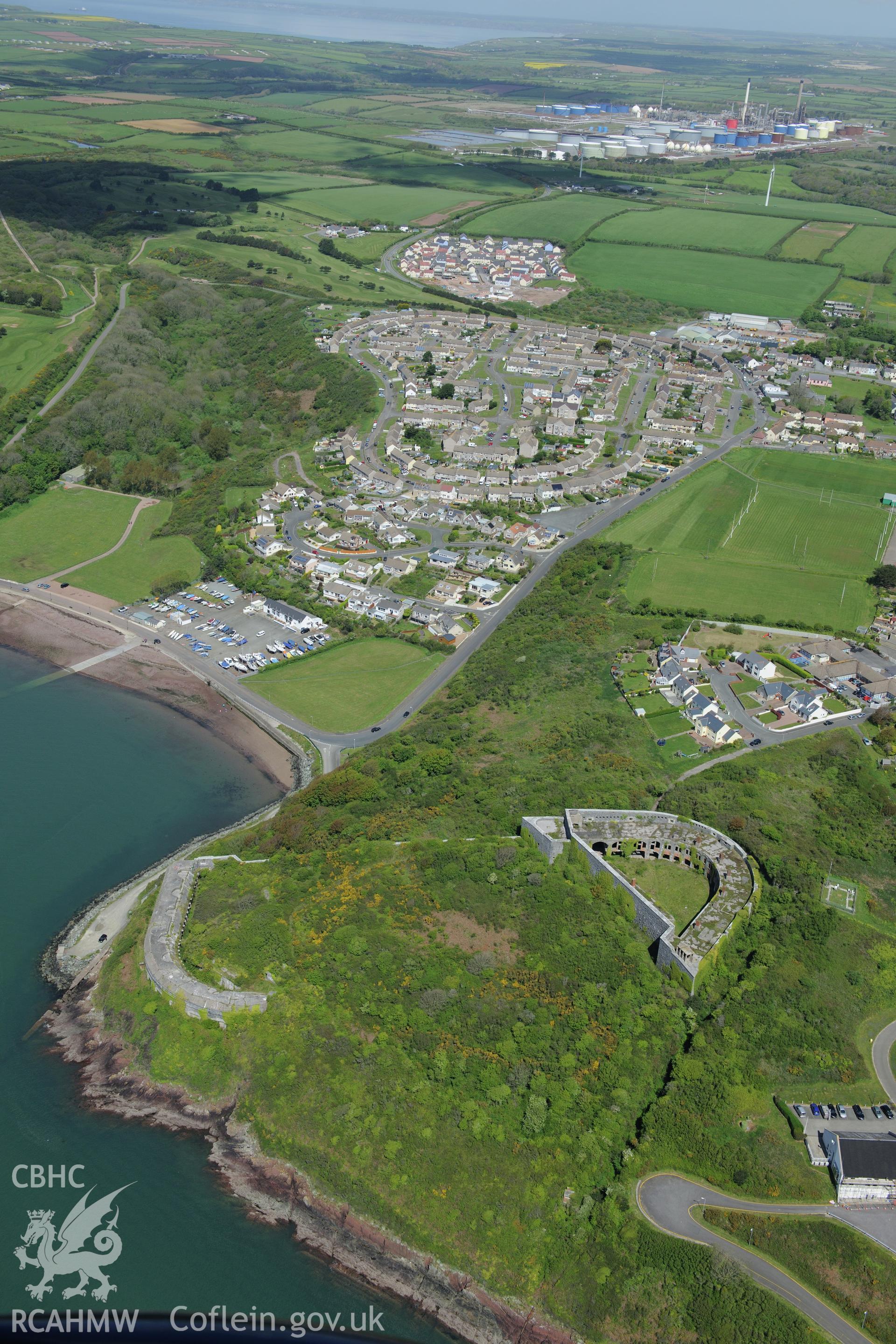 Fort Hubberston, with Hubberston, Milford Haven and the Esso Oil Refinery beyond. Oblique aerial photograph taken during the Royal Commission's programme of archaeological aerial reconnaissance by Toby Driver on 13th May 2015.