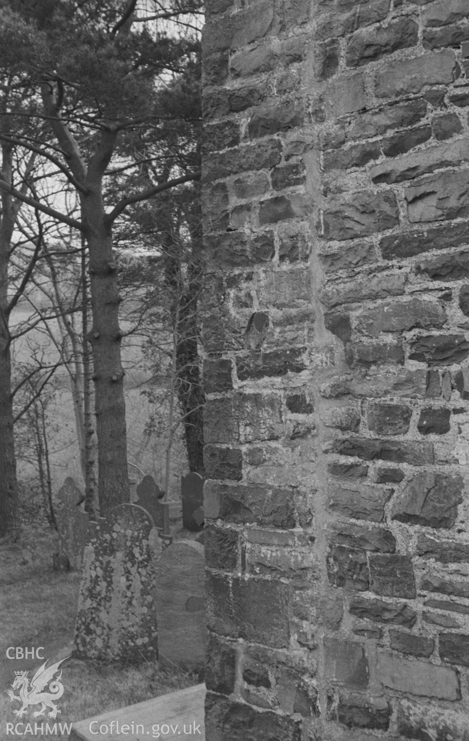 Digital copy of a black and white negative showing the north west corner of St. David's Church, showing the two fragments with Latin inscriptions of 6th century, built in upside down. Photographed in April 1963 by Arthur O. Chater.