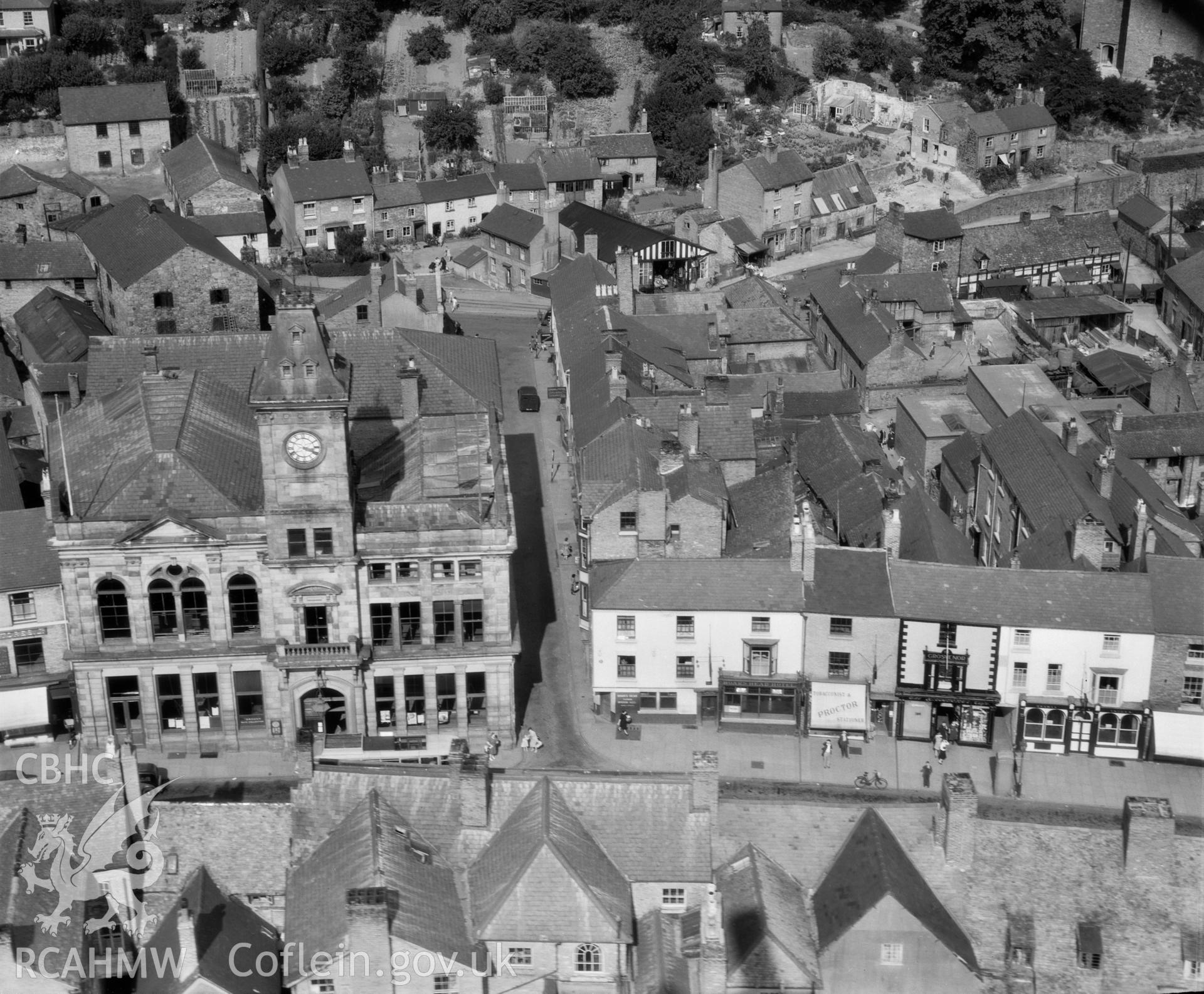 View of Welshpool's Town Hall and Market in 1947, looking north east; at the end of the narrow lane adjacent can be seen the tracks of the Welshpool and Llanfair narrow-gauge railway with a train visible on the extreme right hand side.