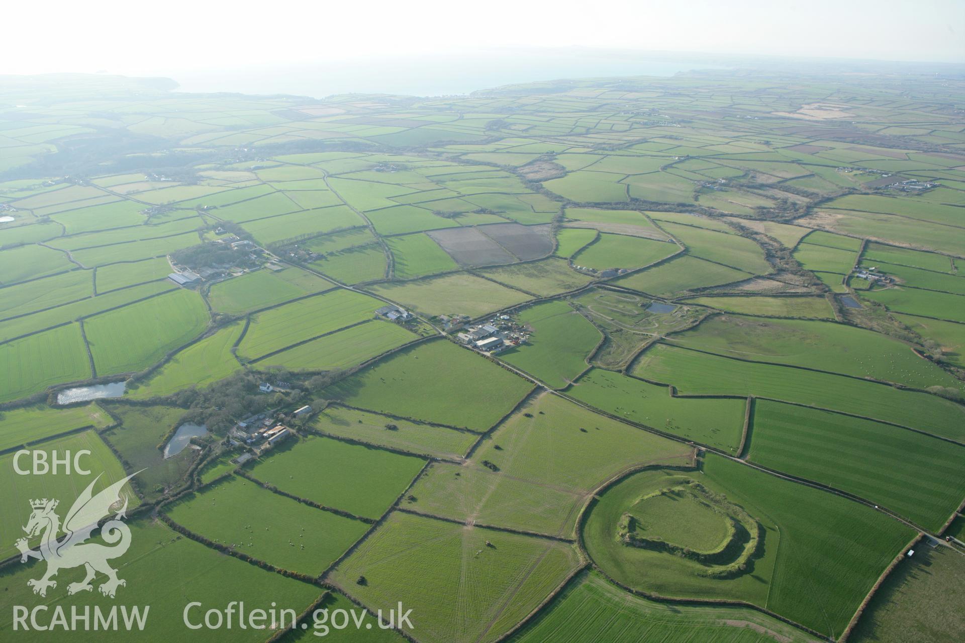 RCAHMW colour oblique aerial photograph of Romans Castle. A wide landscape view. Taken on 13 April 2010 by Toby Driver