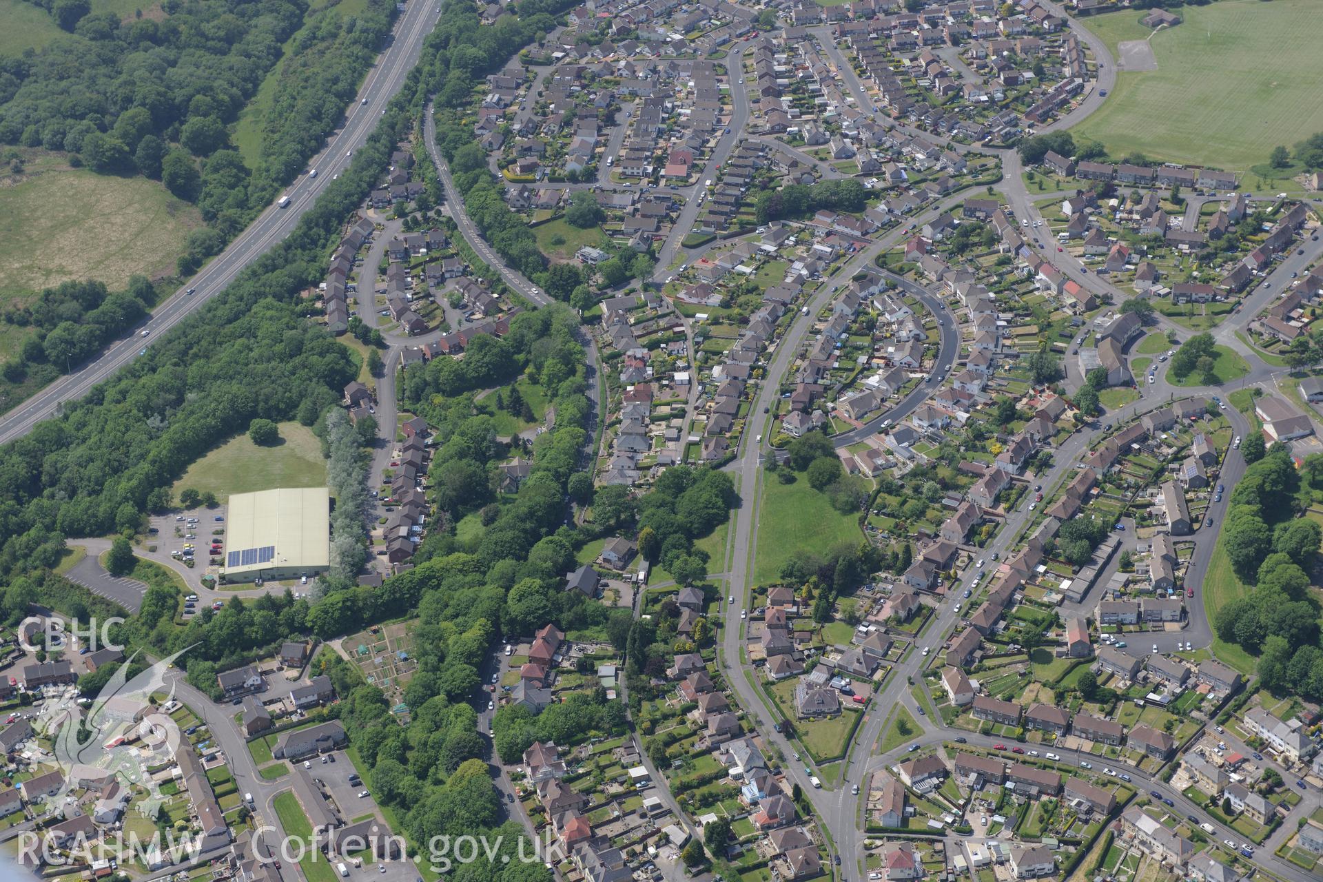 Pontllanfraith village, with Penllwyn Fawr enclosure at it's centre. Oblique aerial photograph taken during the Royal Commission's programme of archaeological aerial reconnaissance by Toby Driver on 11th June 2015.